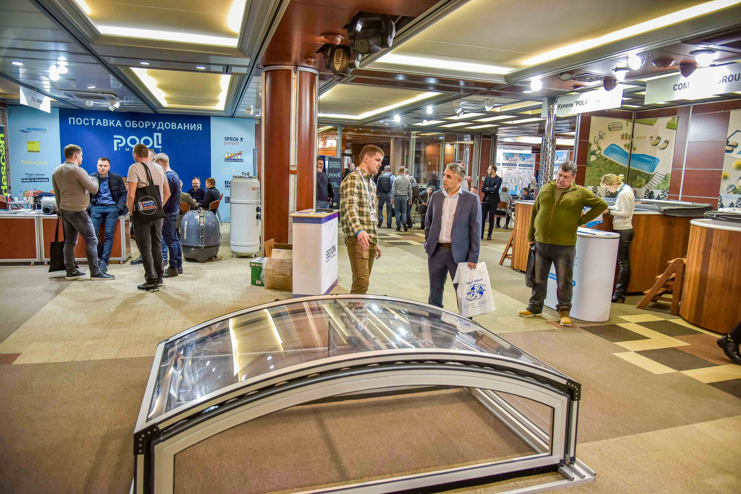 Репортажная съемка с выставки в Москве: снимок передаёт общение между представителем компании и посетителями выставки.