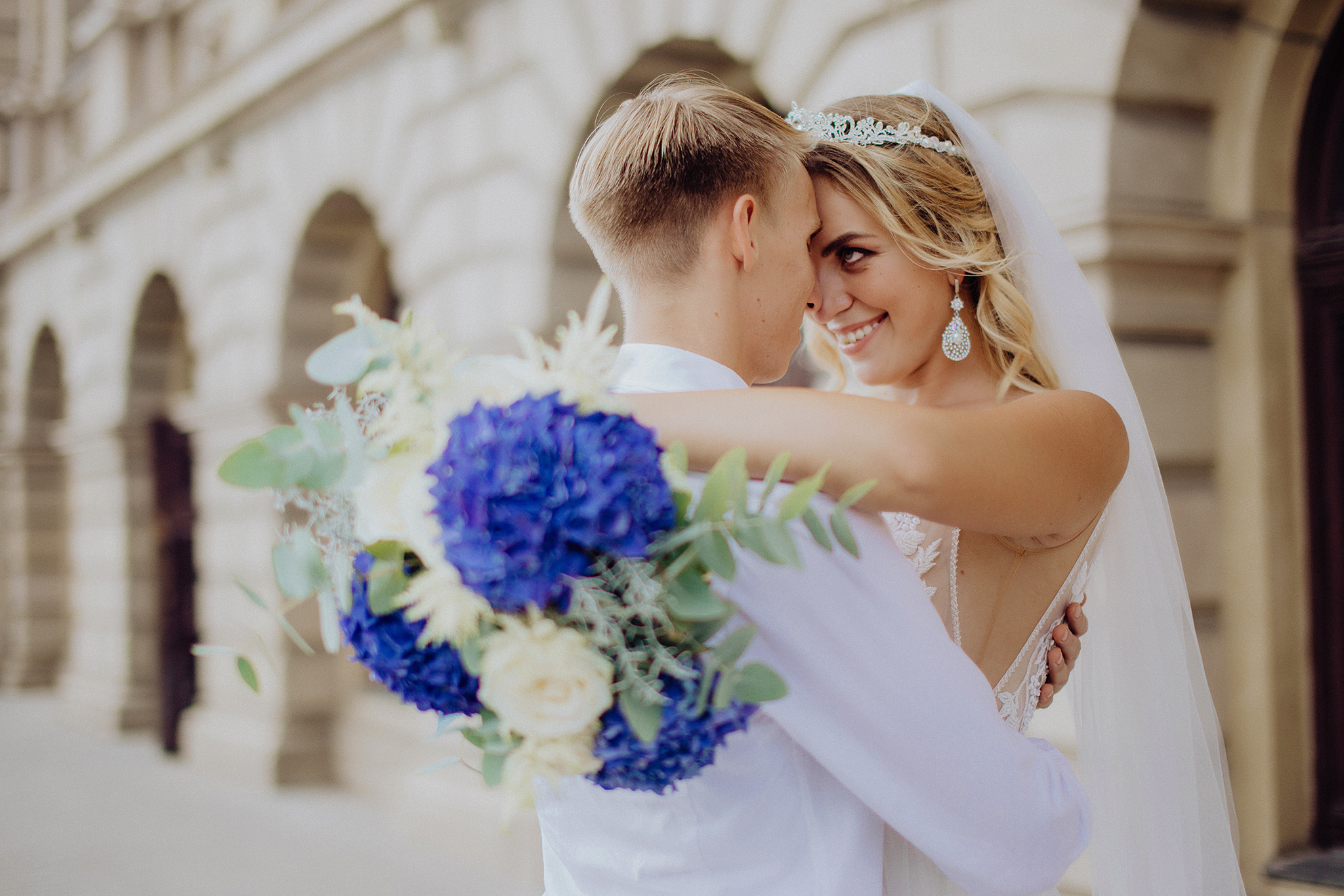 Жених и невеста обнимаются на свадебной прогулке