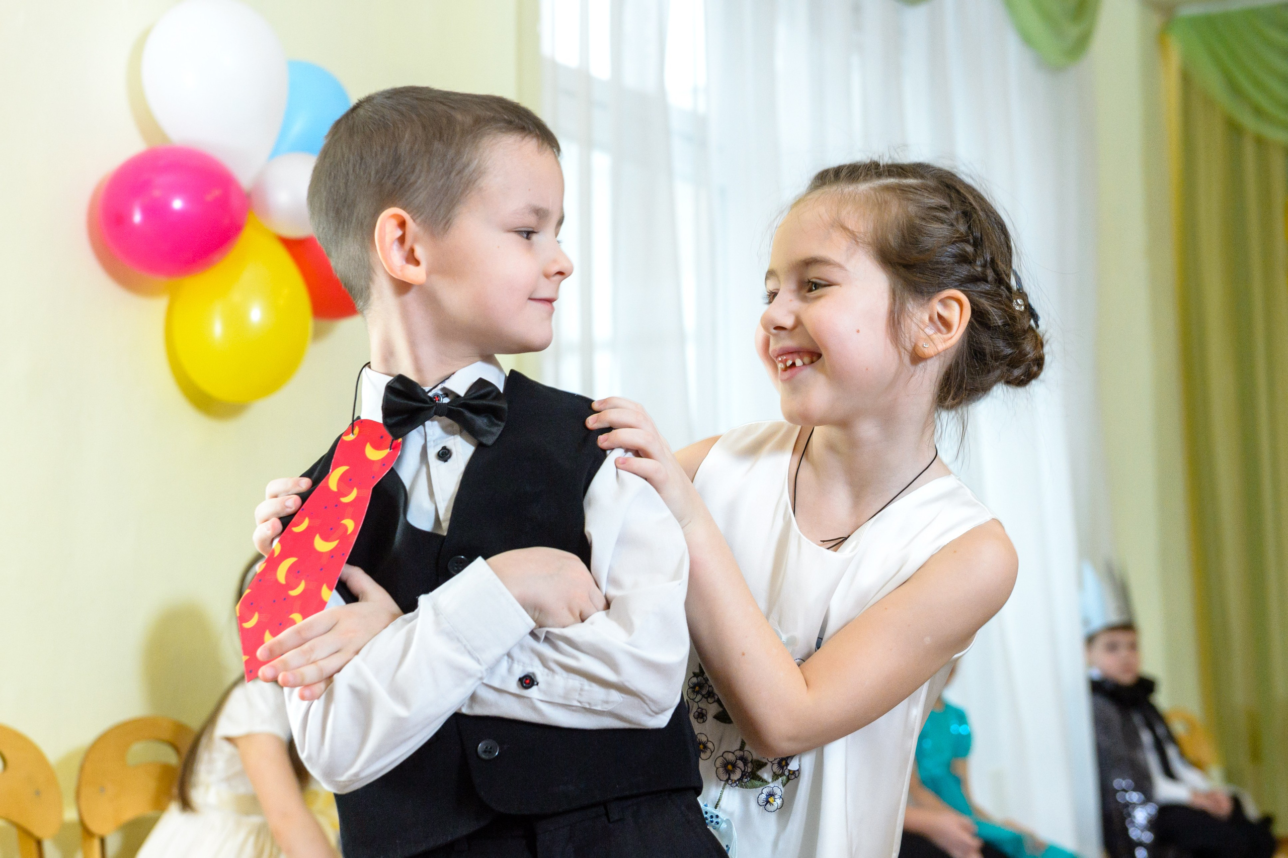 Мальчик и девочка танцуют на утреннике в детском саду.