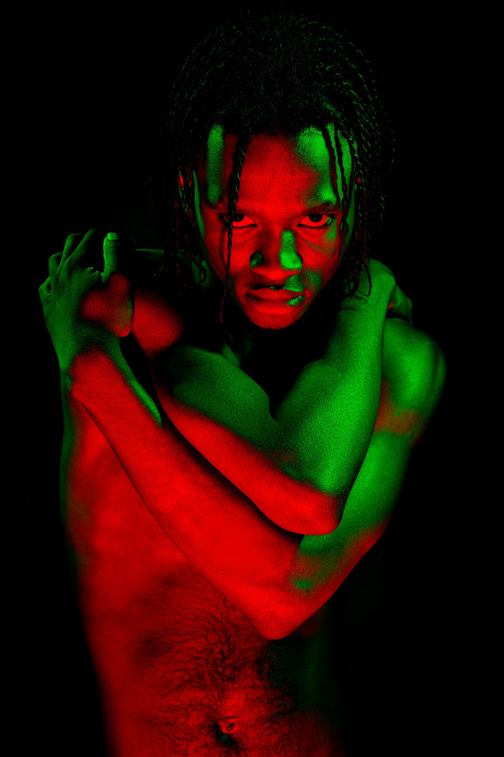 крупный портрет чернокожего юноши в цветном свете 