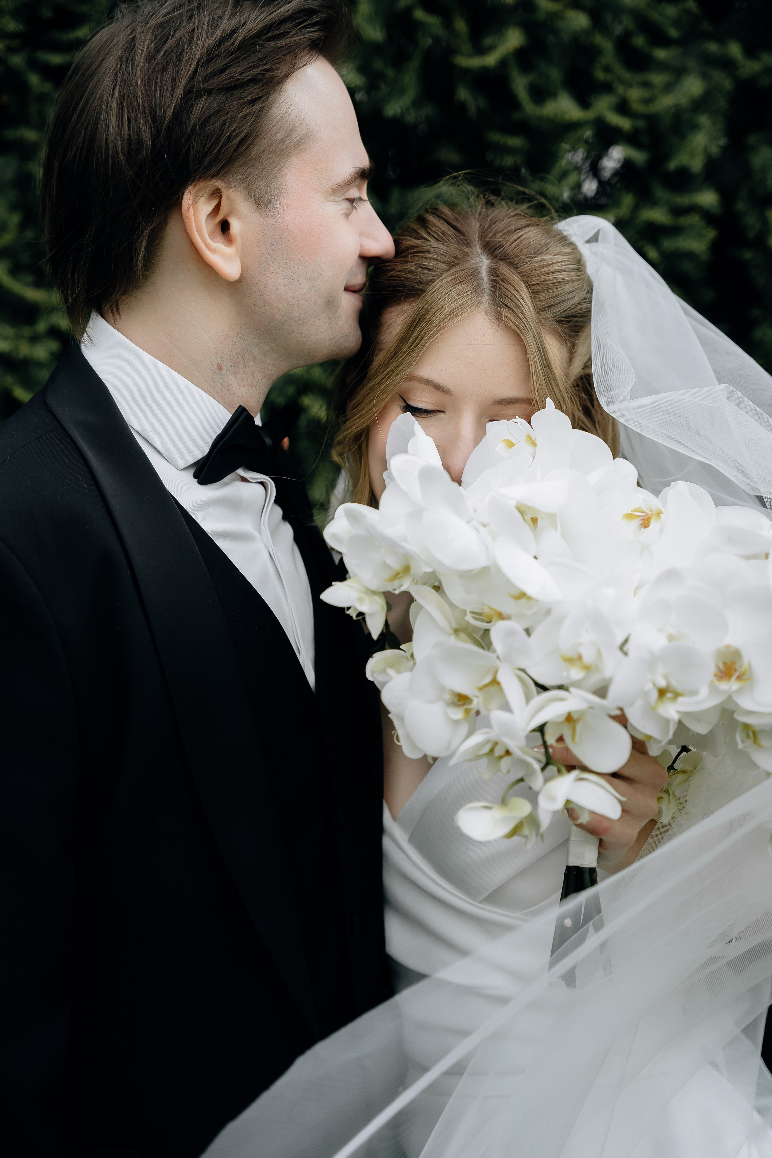 Невеста закрывается букетом из орхидей