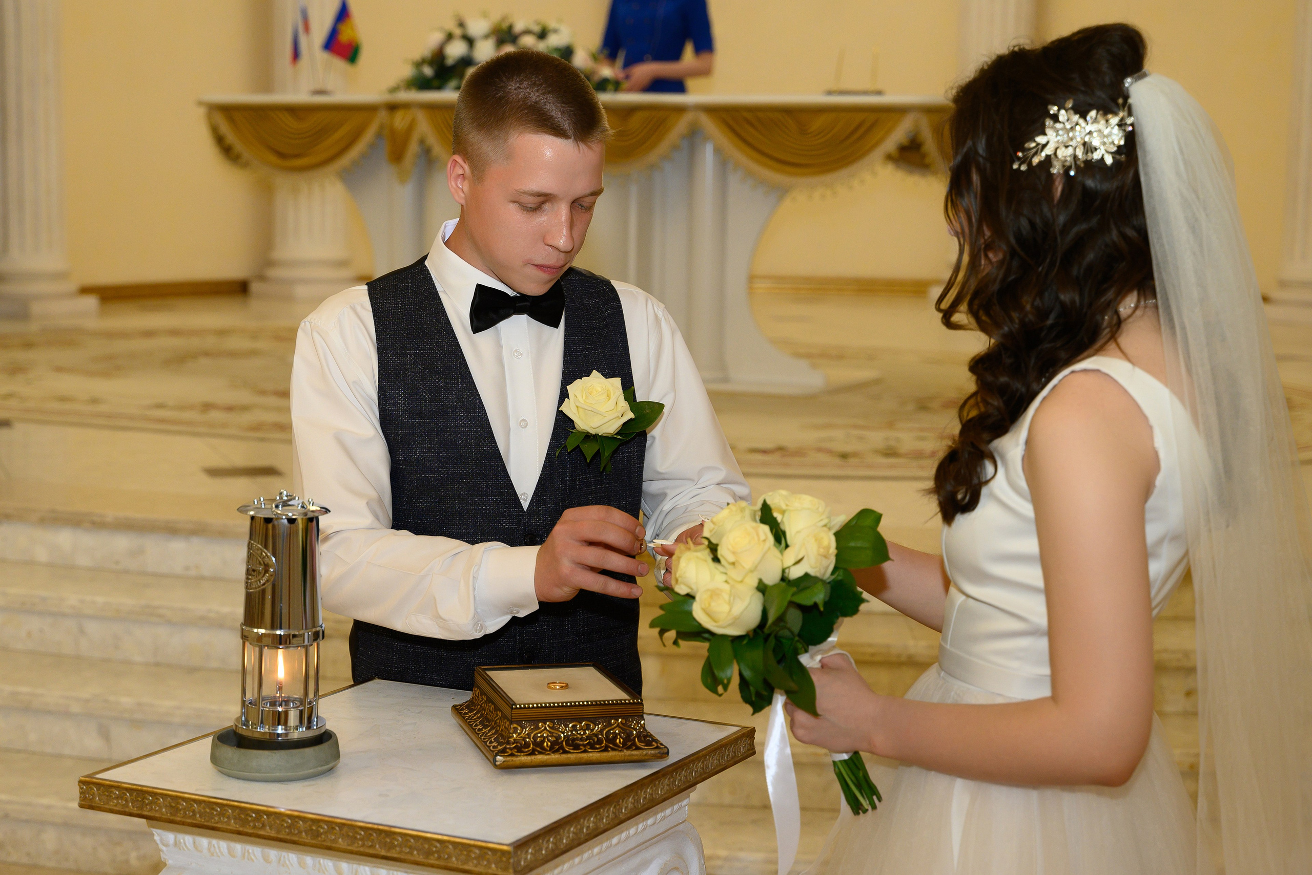 Жених надевает кольцо невесте, красивое позирование для фото.