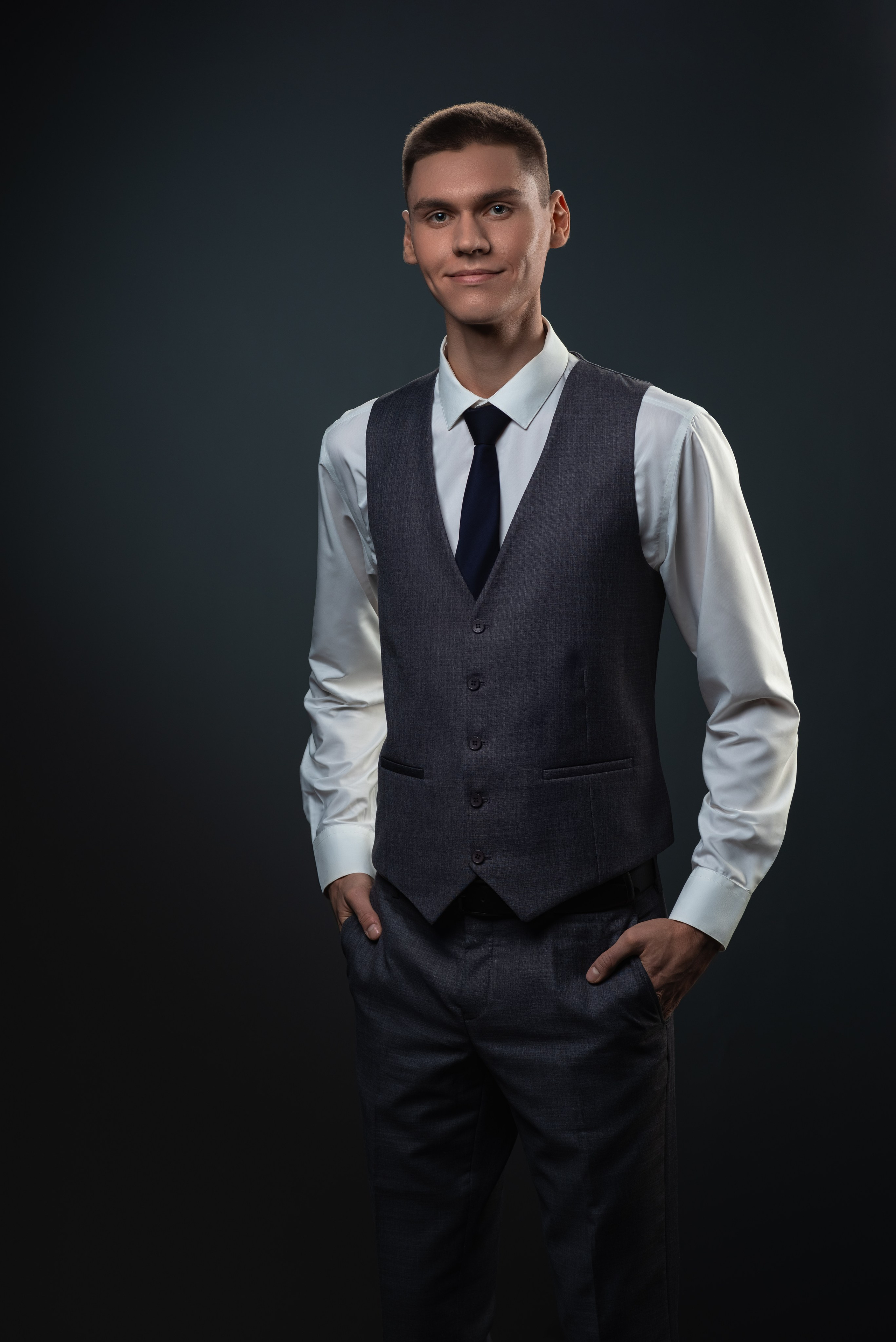 Портрет молодогопарня В белой рубашке и сером жилете.