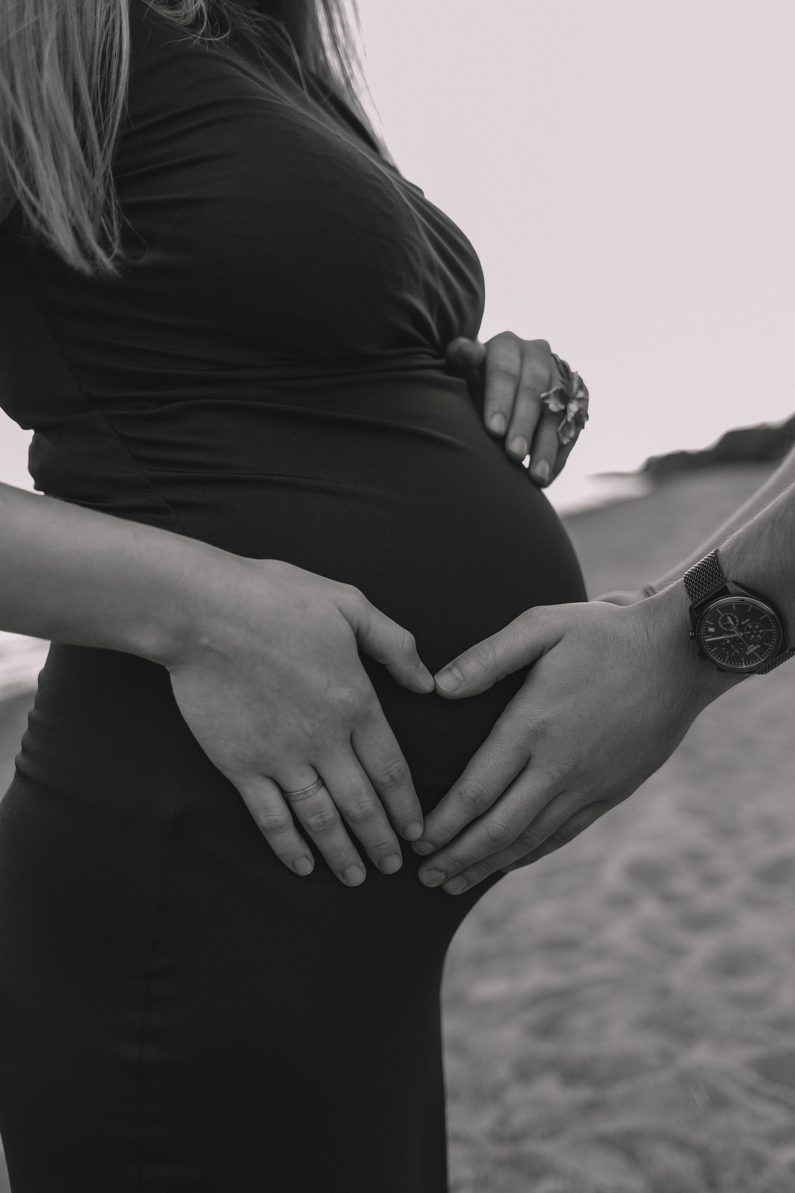 Крупный план живота беременной, руки мужчины