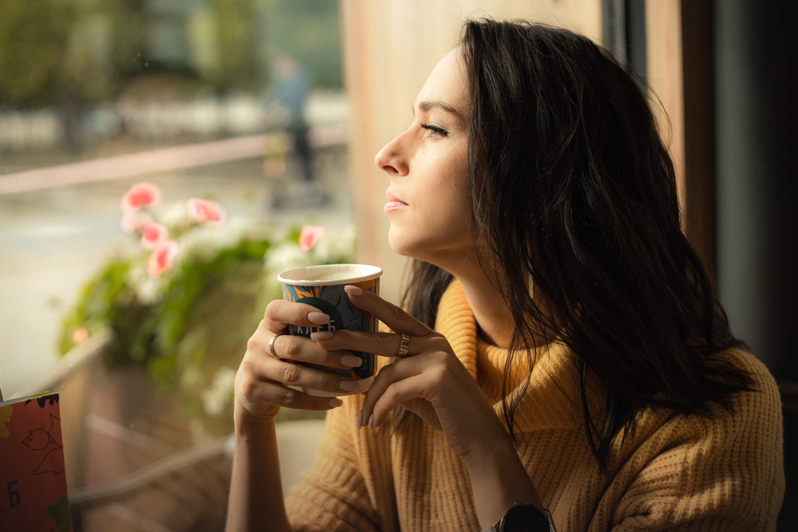 с чашкой кофе у витрины