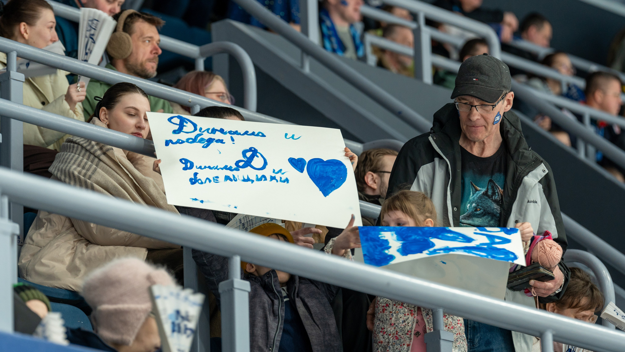 Болельщики «Динамо» с плакатами на трибунах. Спортивная фотосъёмка, репортажный фотограф, Санкт-Петербург, эмоции матча.