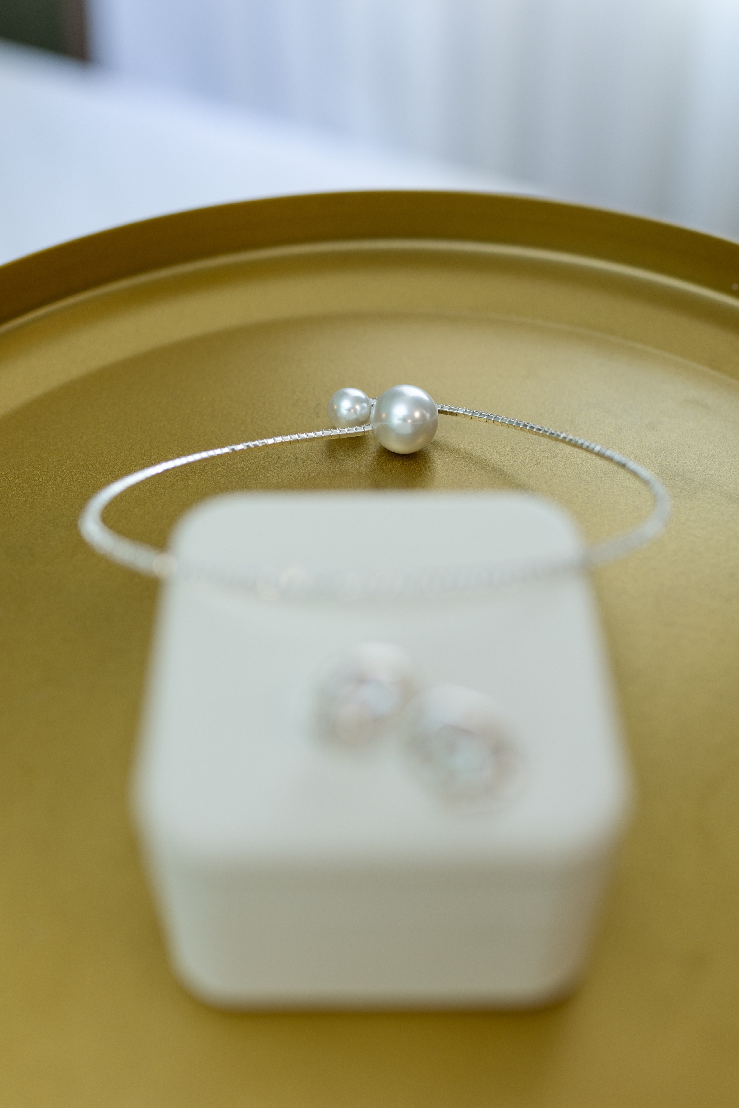 На белой коробочке обручальные кольца браслет.