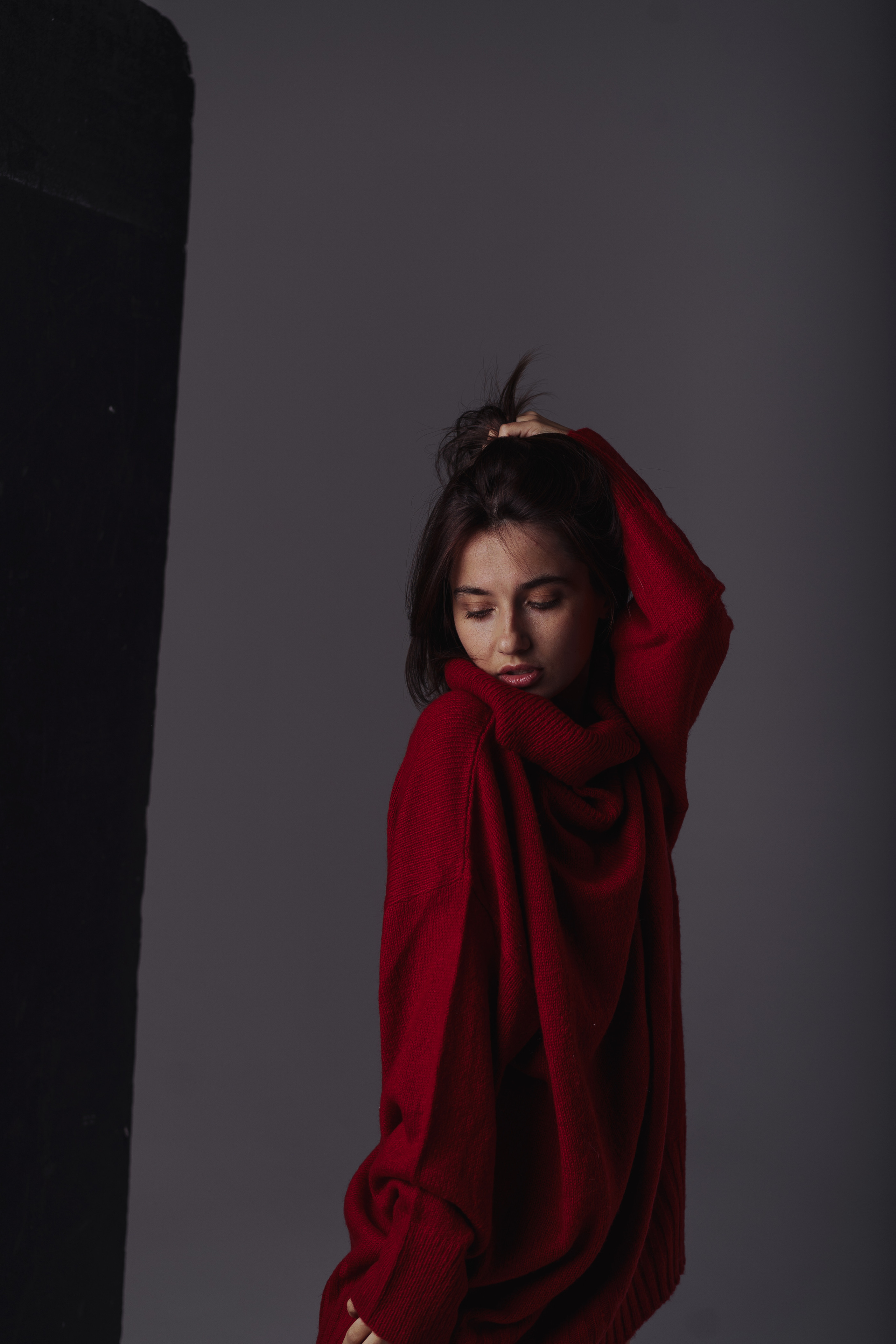 Девушка в красном свитере на циклораме