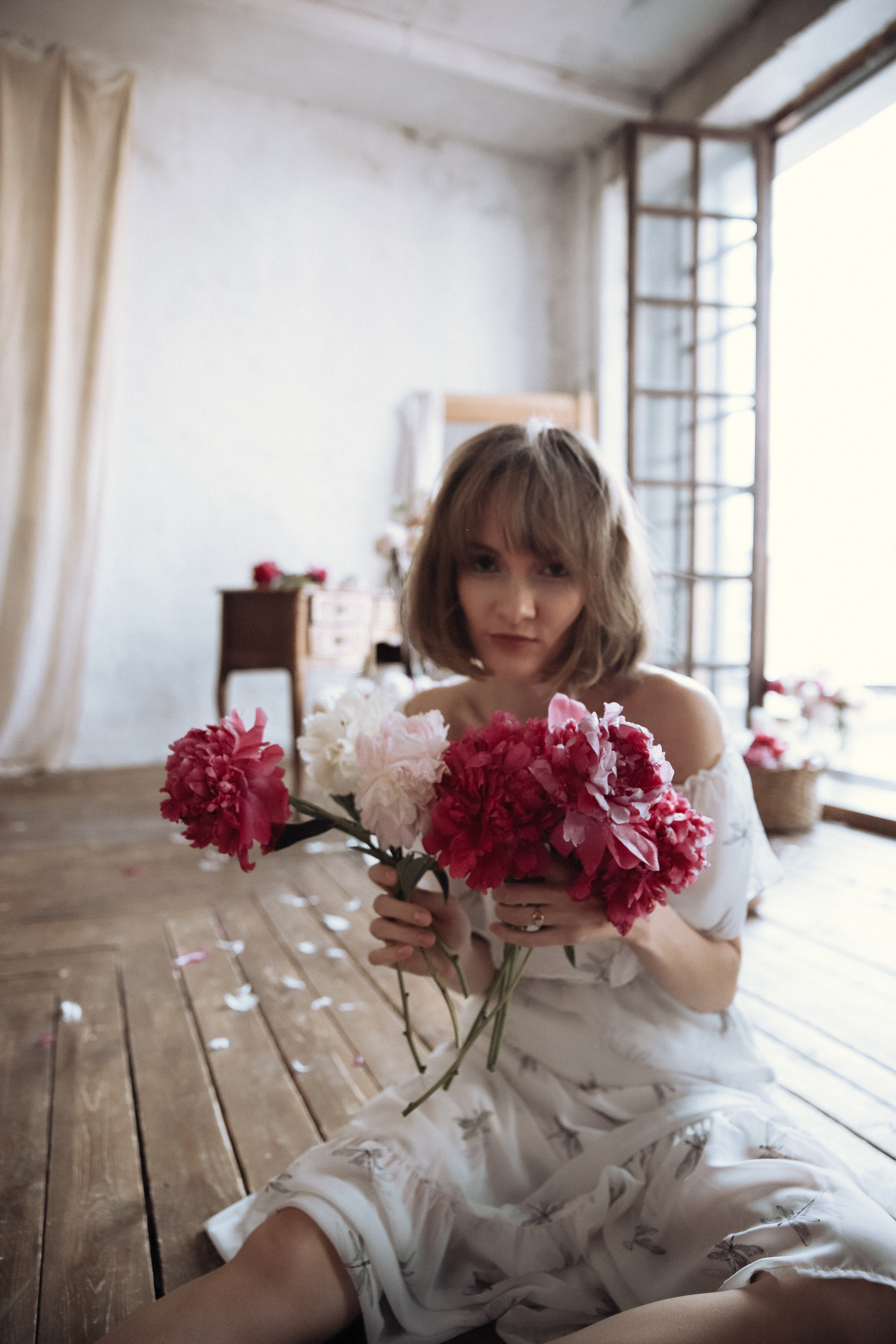 Красивая девушка с пионами смотрит в глаза