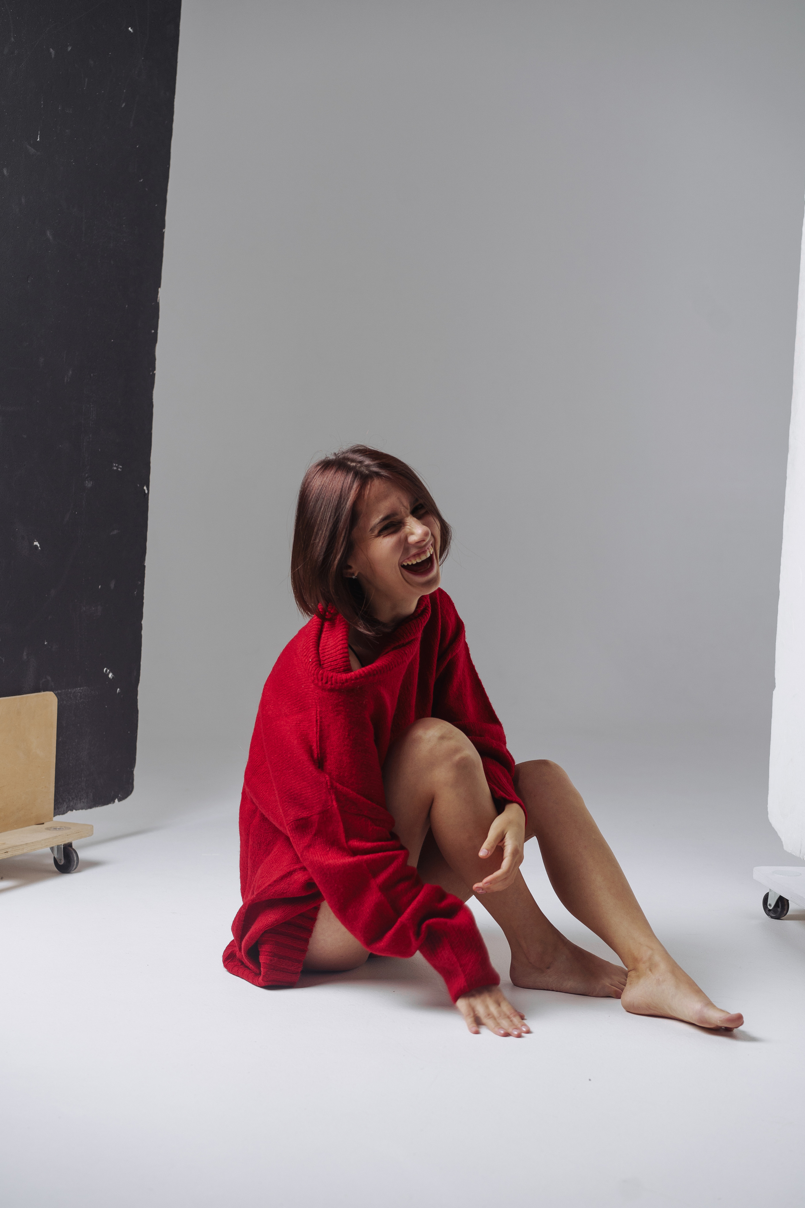 Девушка в красном  свитере смеется