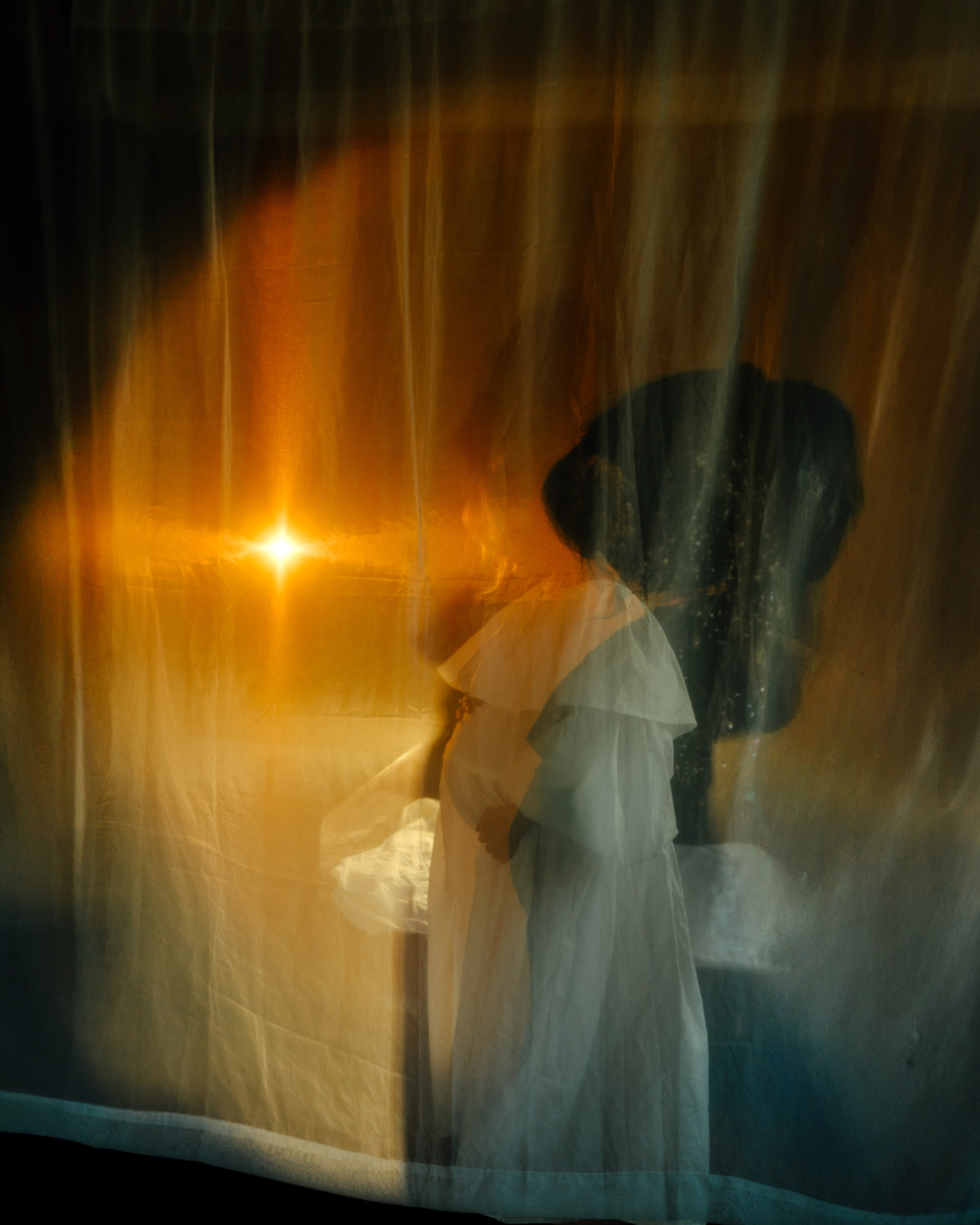 Силуэт беременной за тканью и световой блик, контровой свет — художественная фотосессия беременности в ретро-фотостудии Санкт-Петербурга.