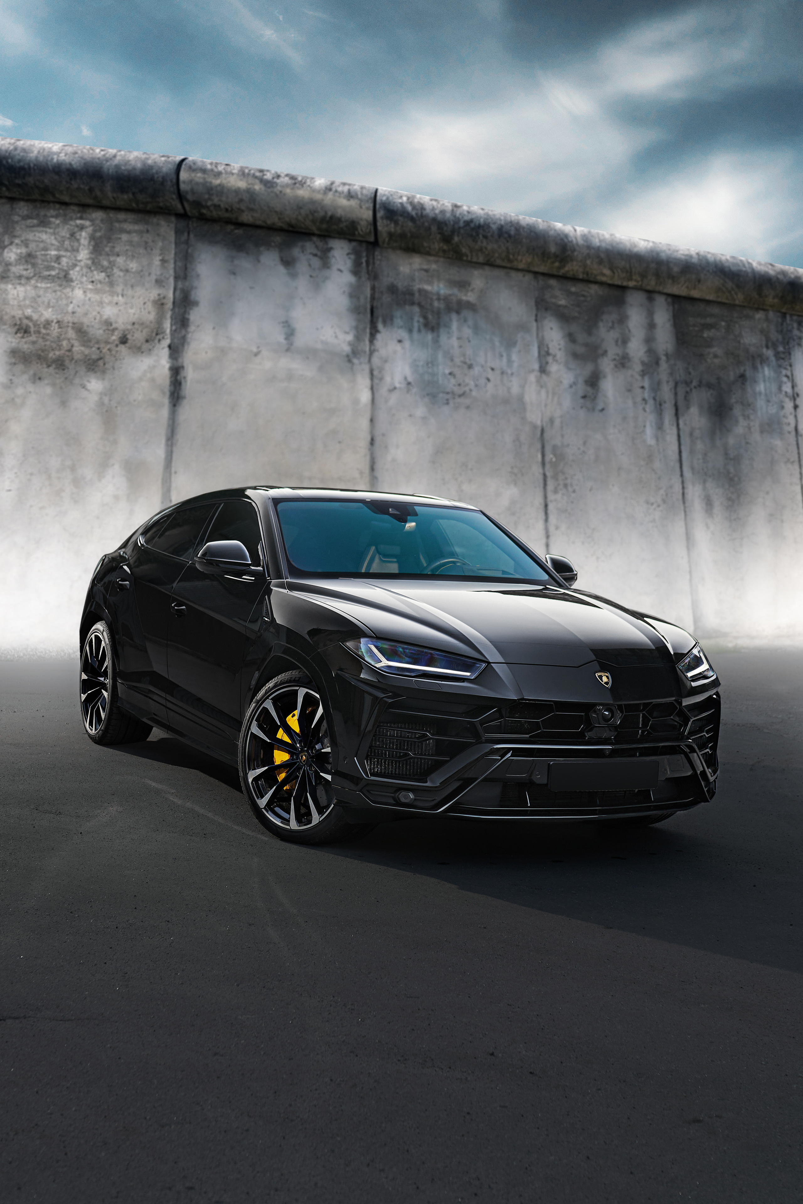Lamborgini urus вид спереди на фоне бетонной стены