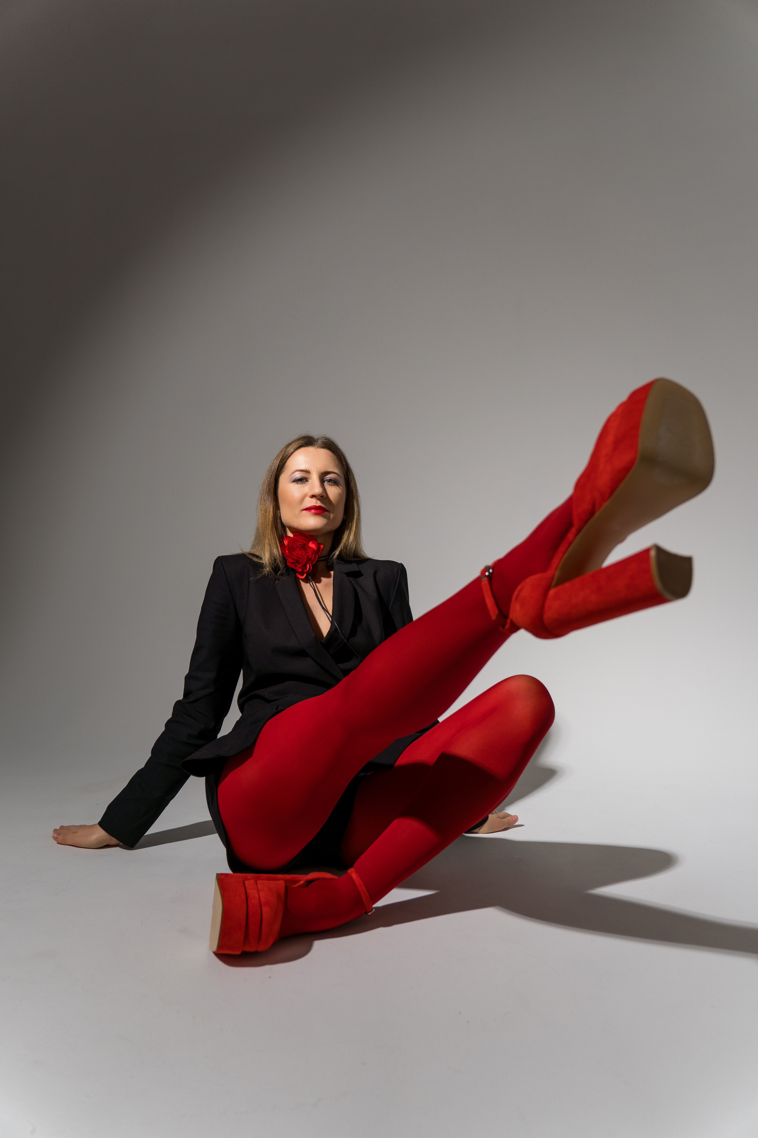 фэшн портрет девушки в красных колготках и красных туфлях на циклораме