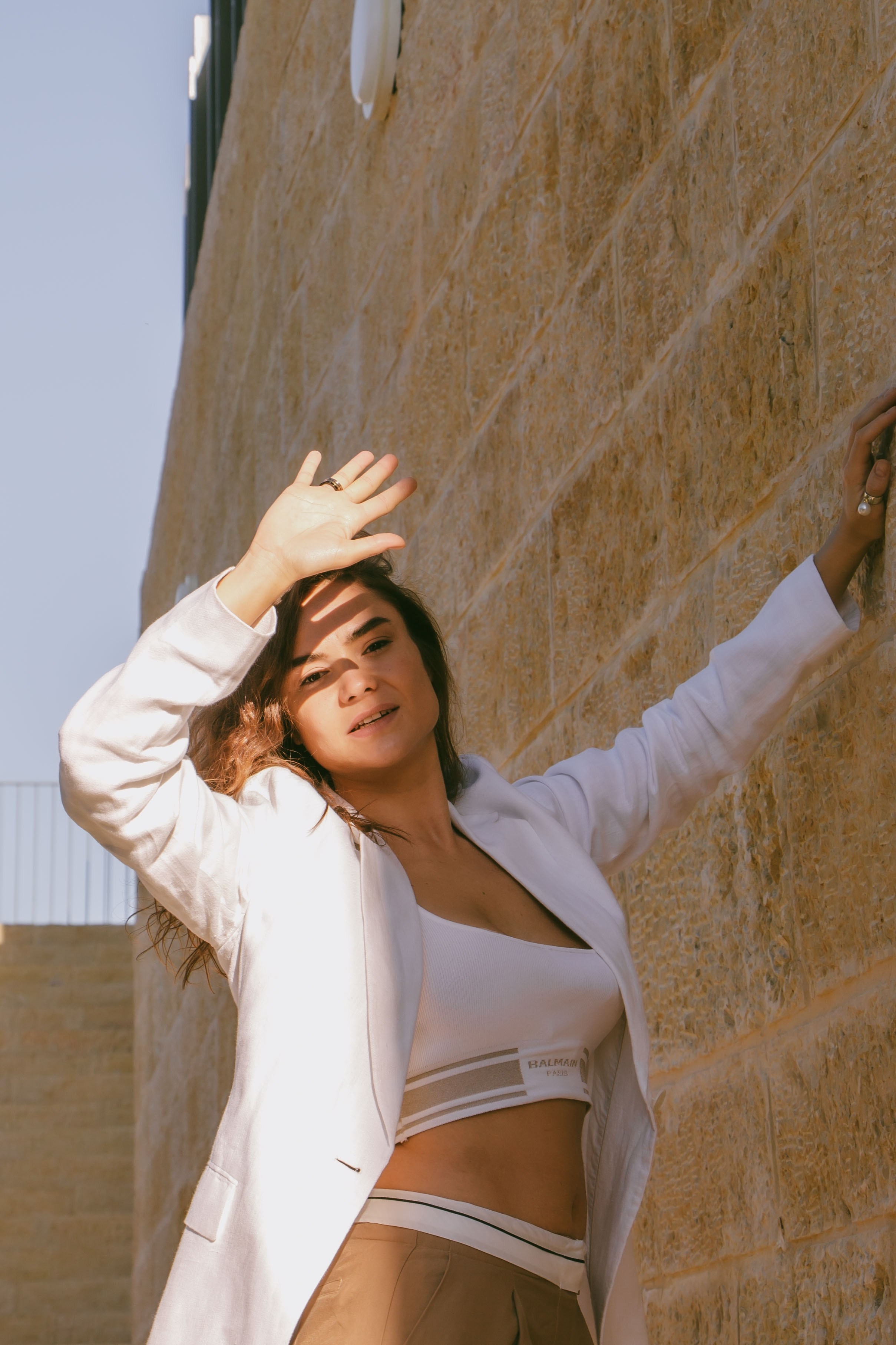 девушка прячется от солнца закрывая лицо рукой