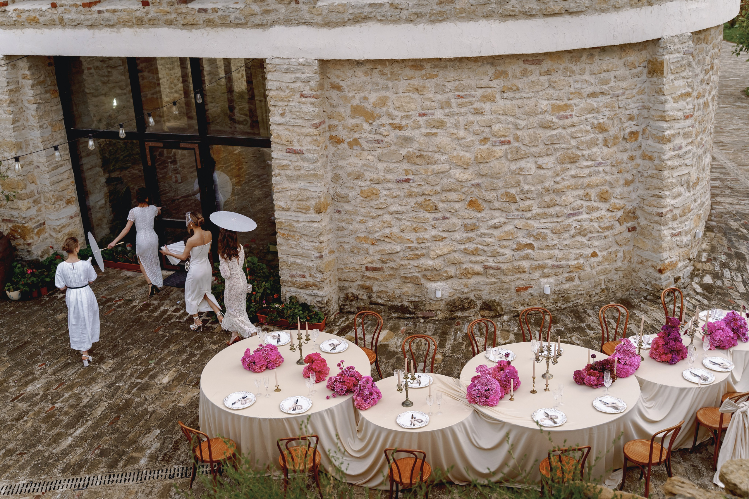 Длинный стол для свадебного ужина на террасе Chateau Andre, украшенный цветами и свечами