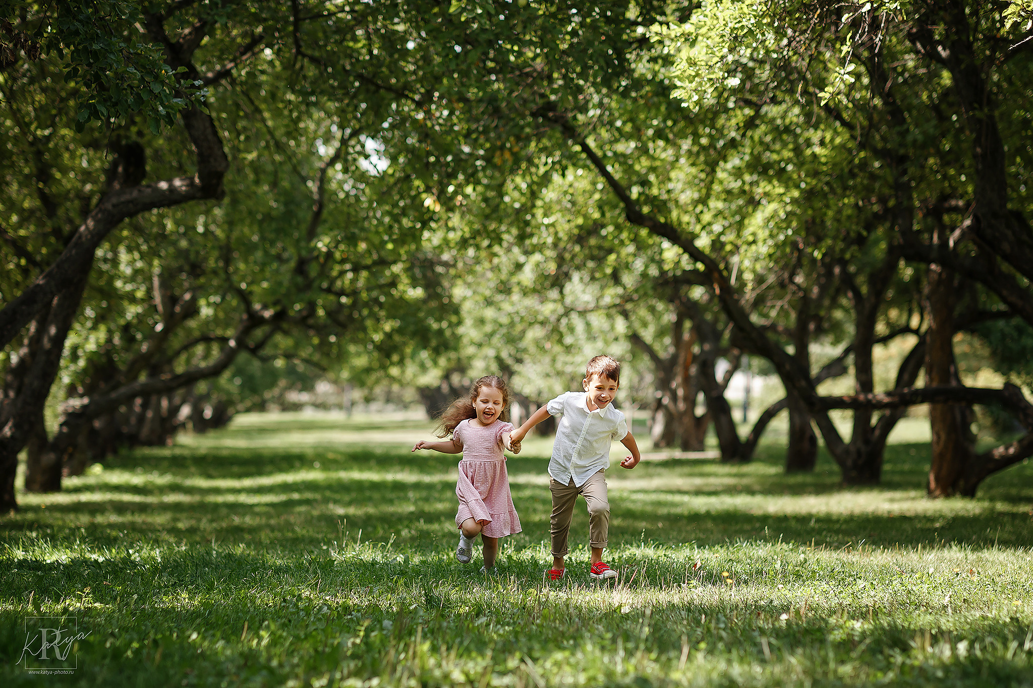 дети бегут по яблоневому саду