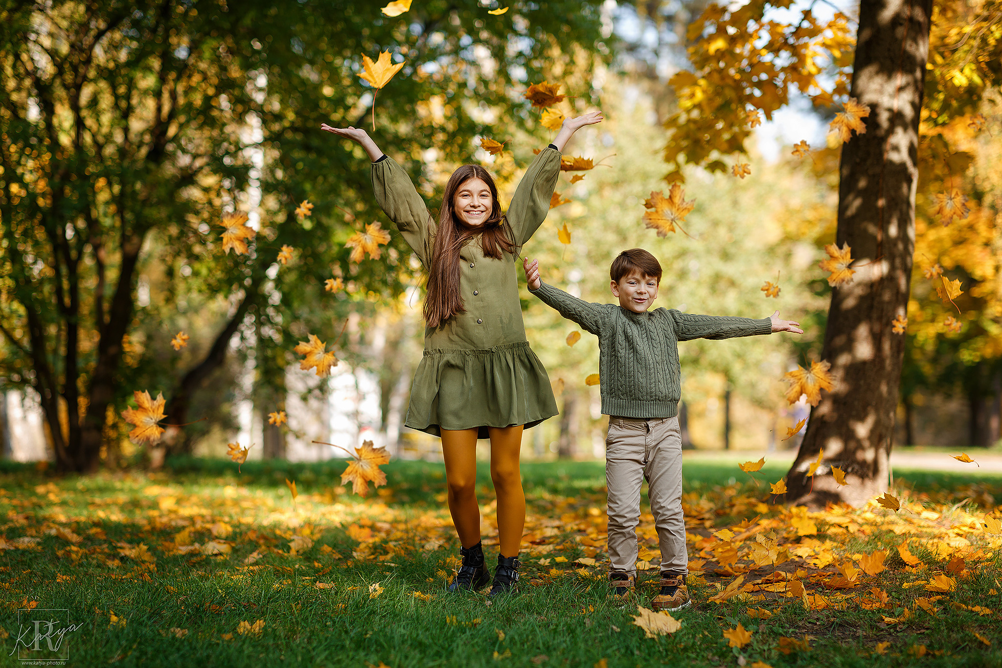 дети кидаются осенними листьями