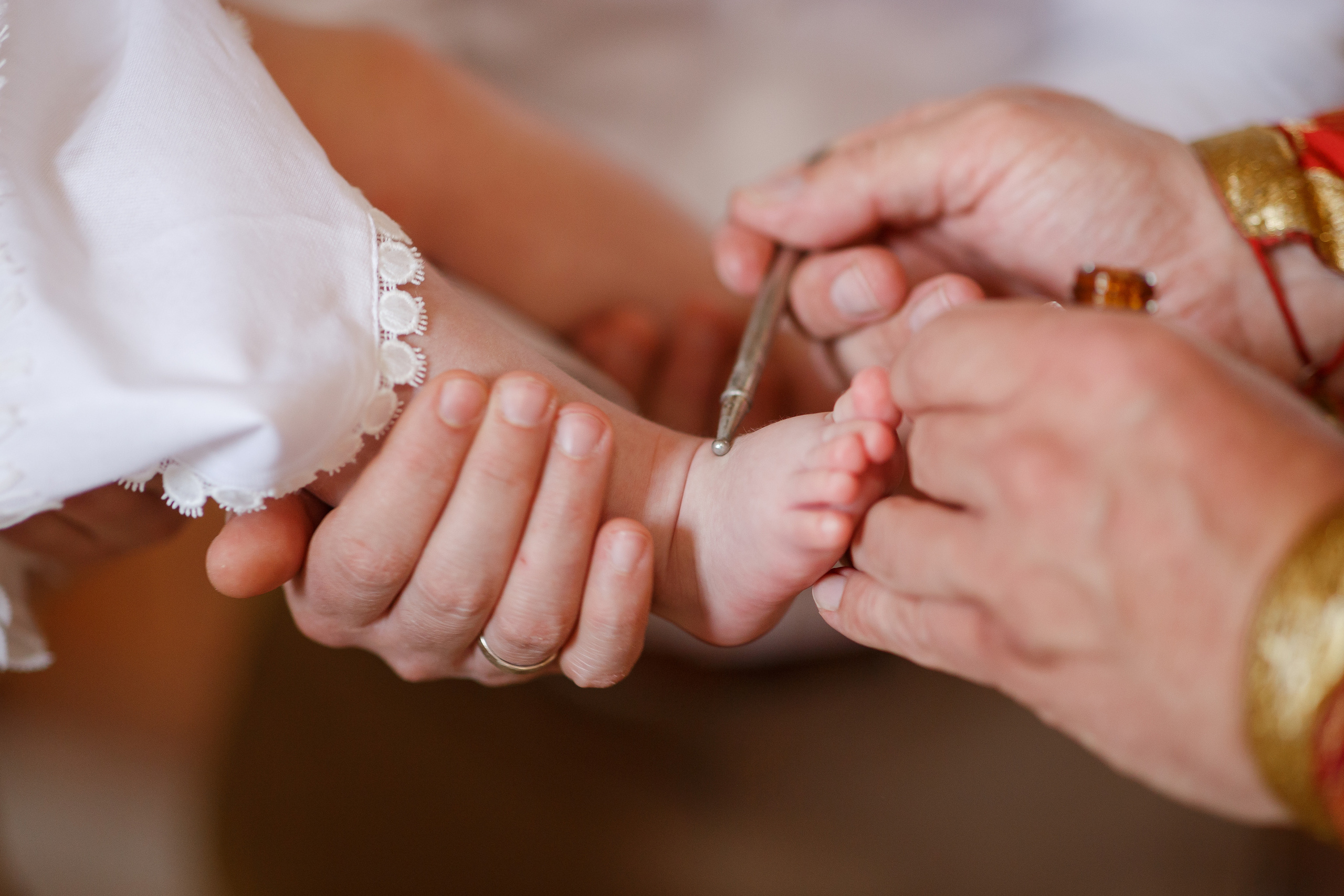 священник мажет ногу ребенку