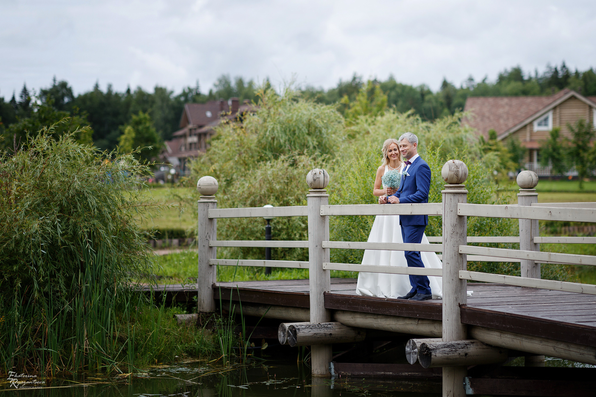жених и невеста стоят на мосту
