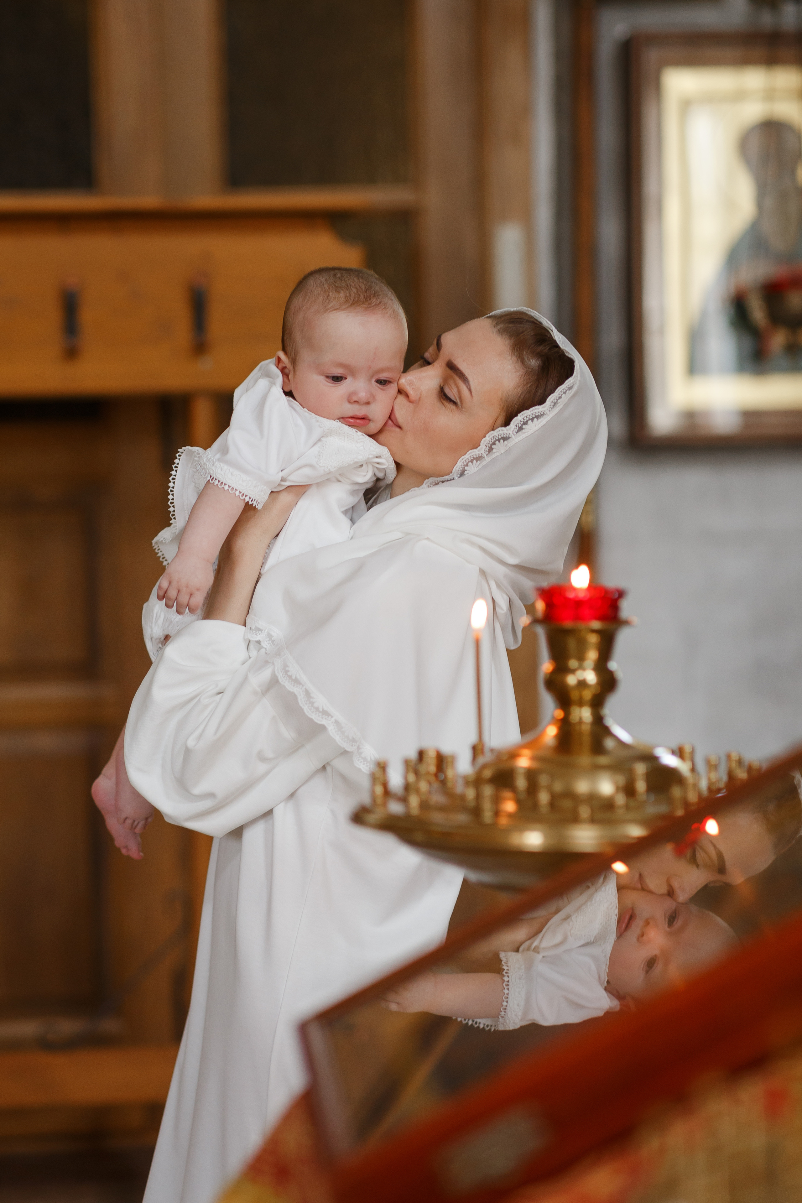 мама целует ребенка в церкви
