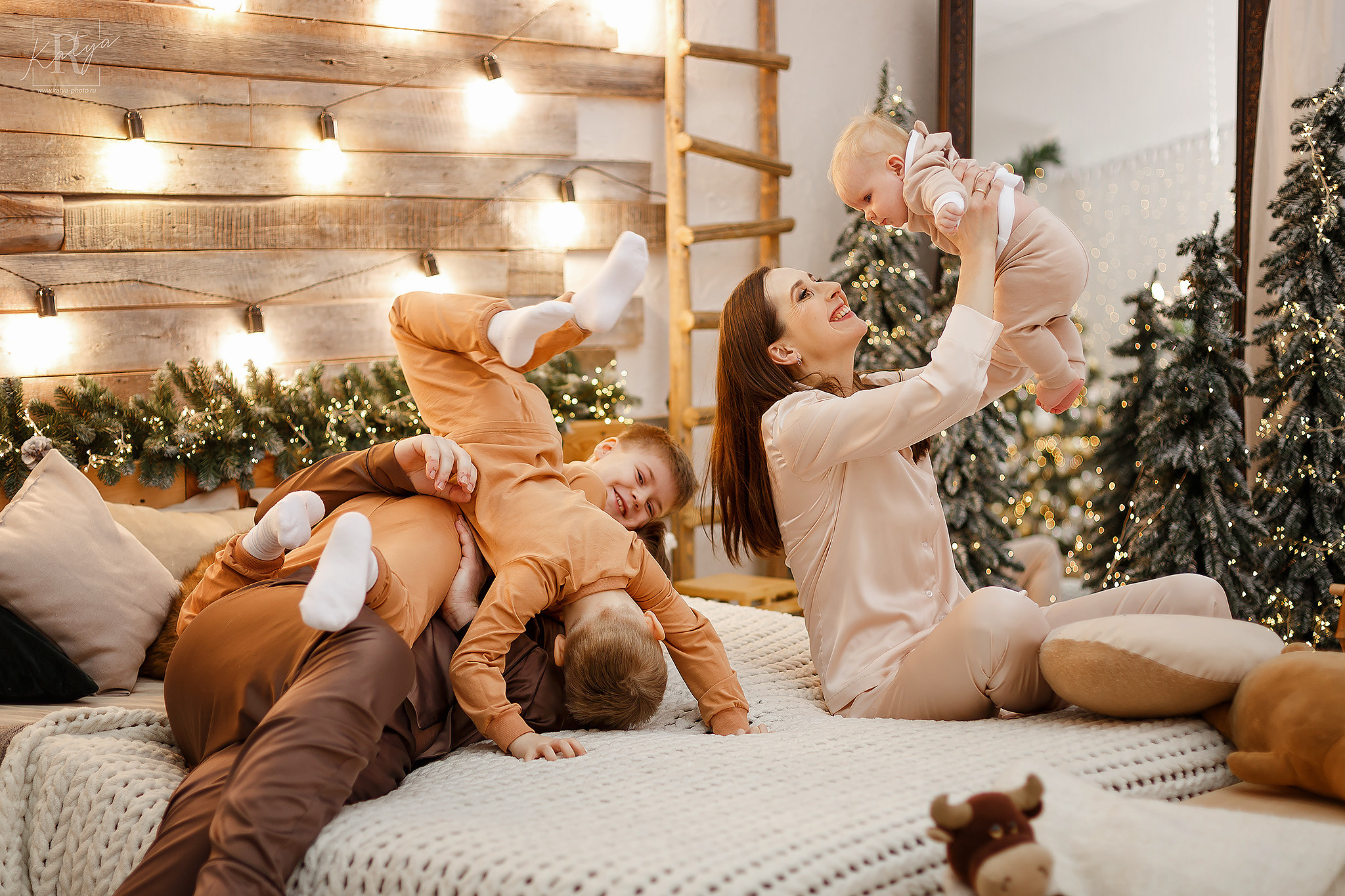 родители и дети играют на кровати