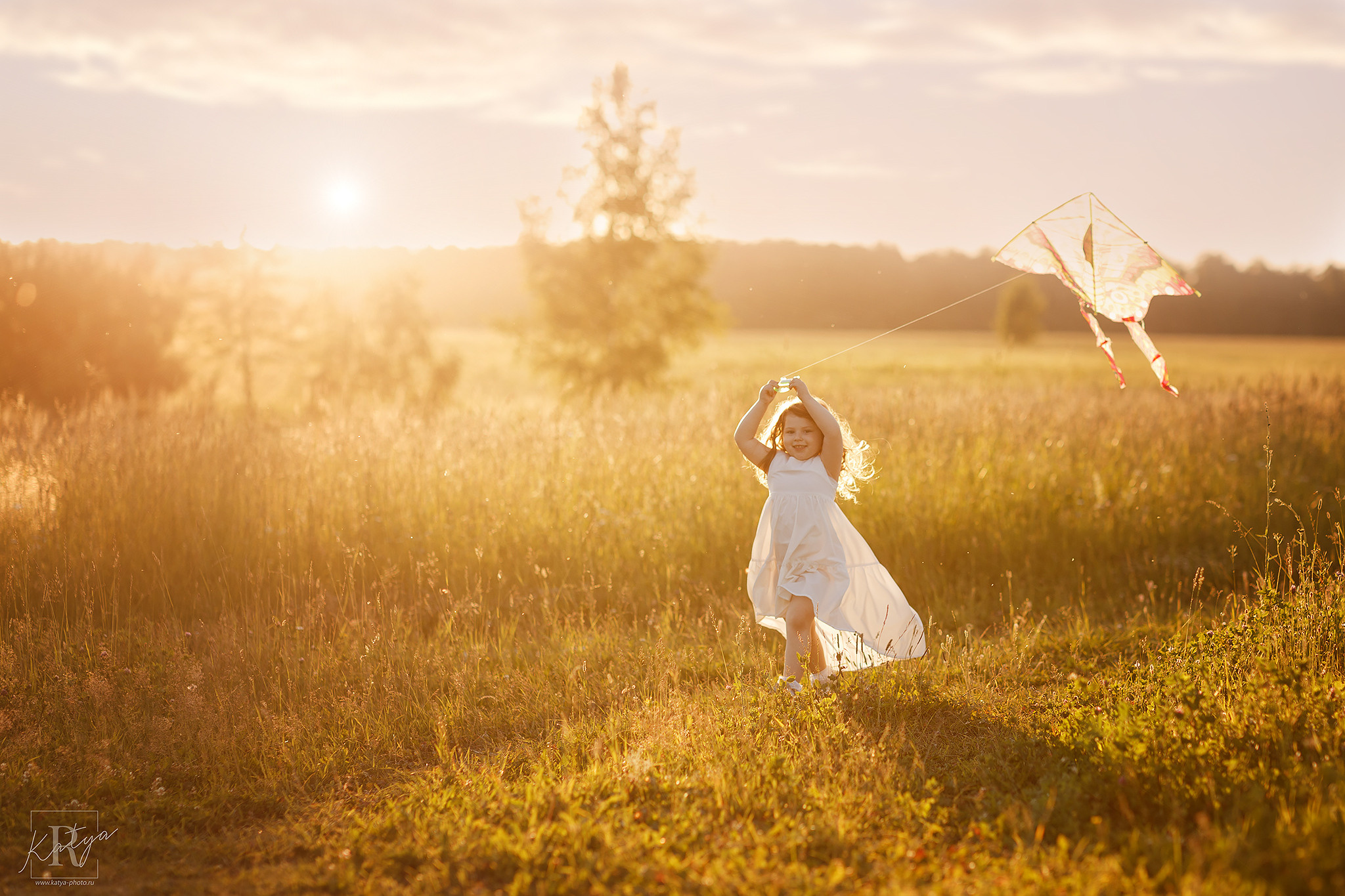 девочка с воздушным змеем бежит по полю