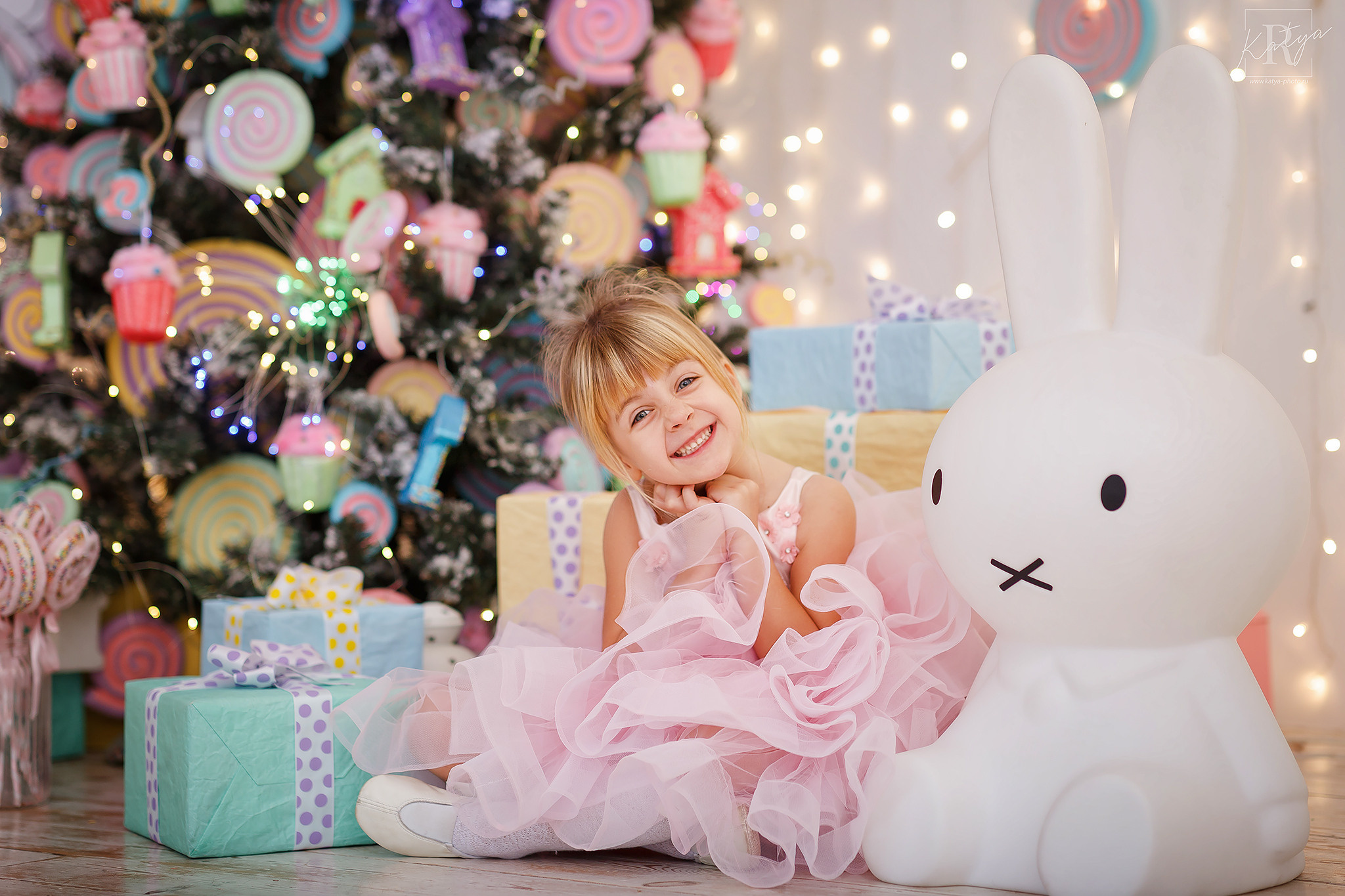 девочка в розовом платье сидит под ёлкой