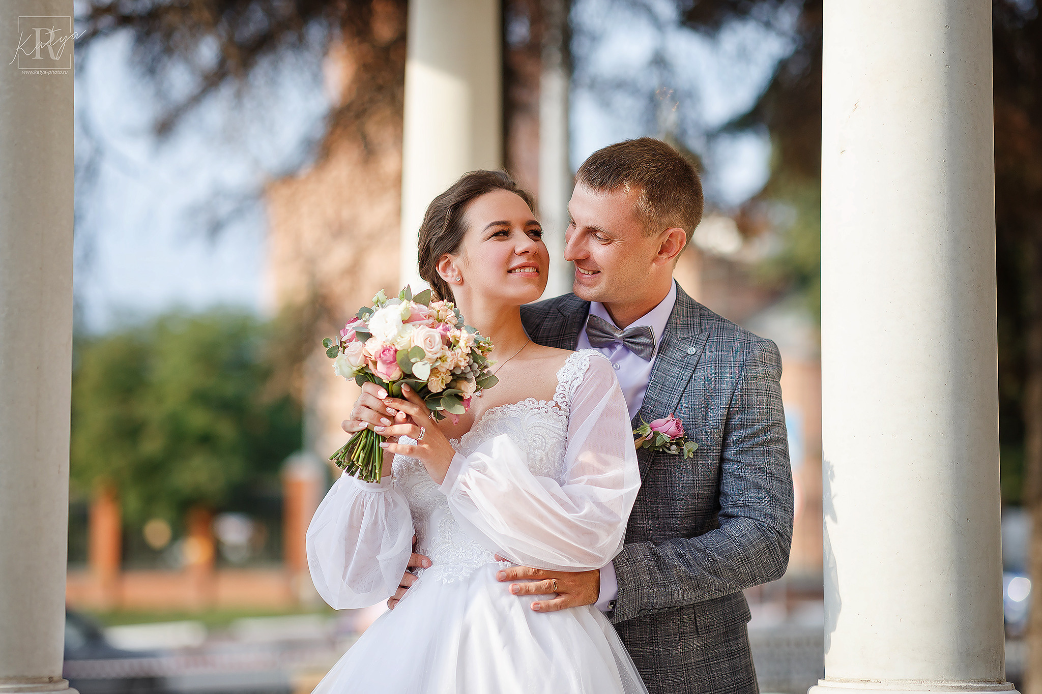 молодожёны стоят среди колонн