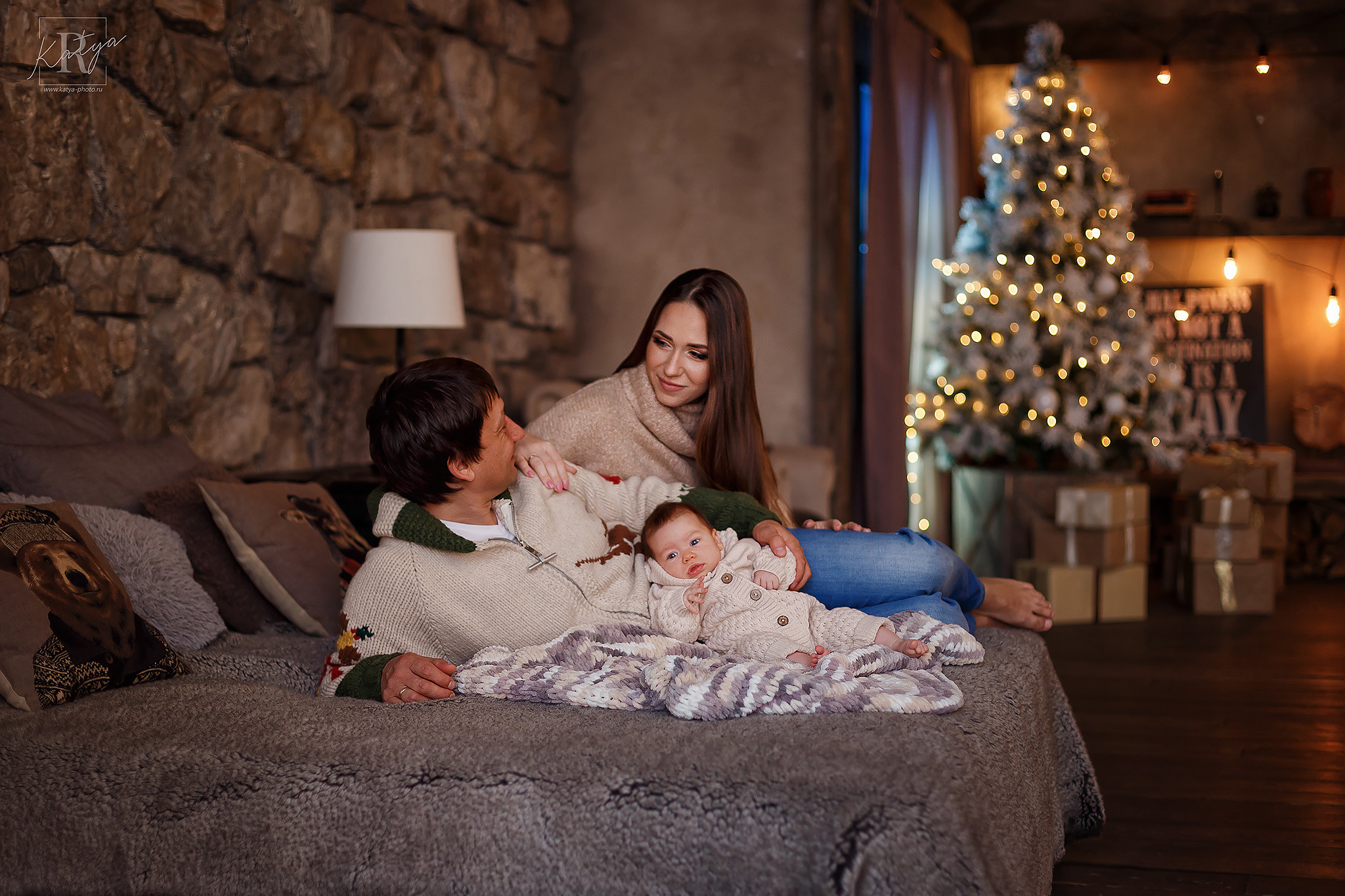 мама, папа и малыш лежат на кровати в зале Парнас