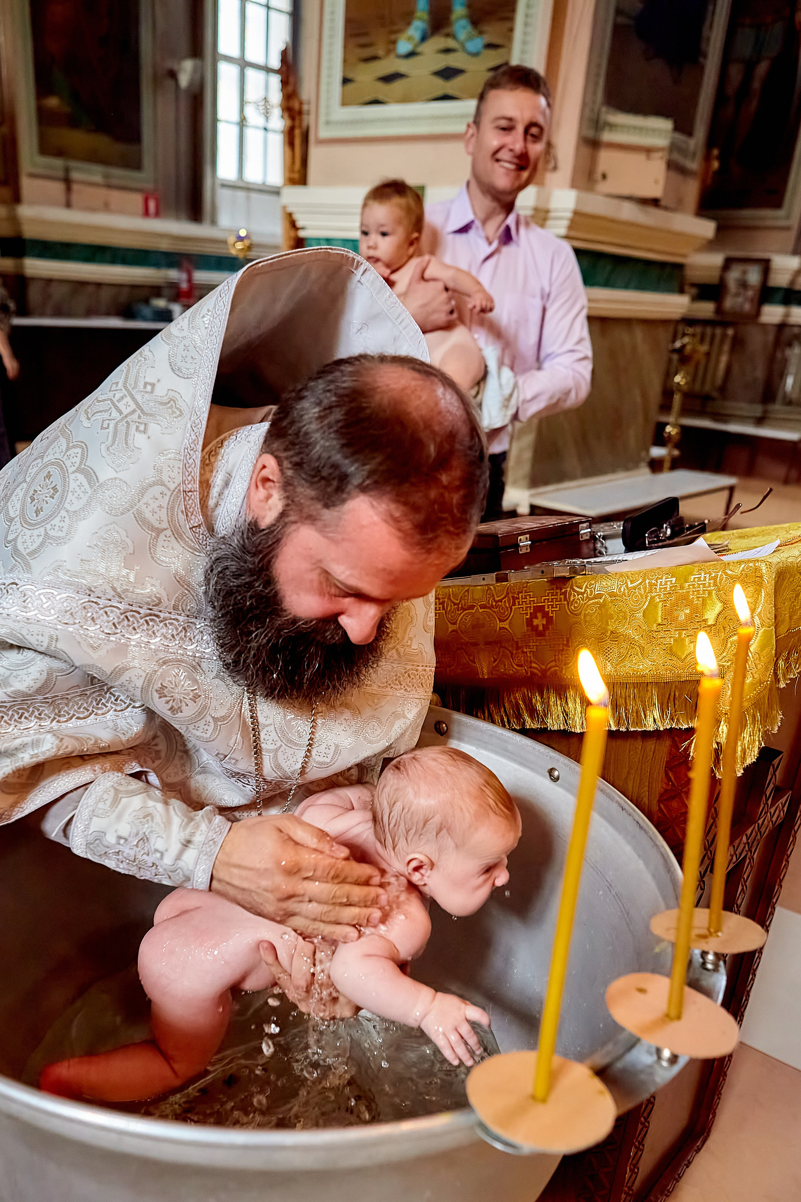 Трижды окунается младенец в купели на Крещении
