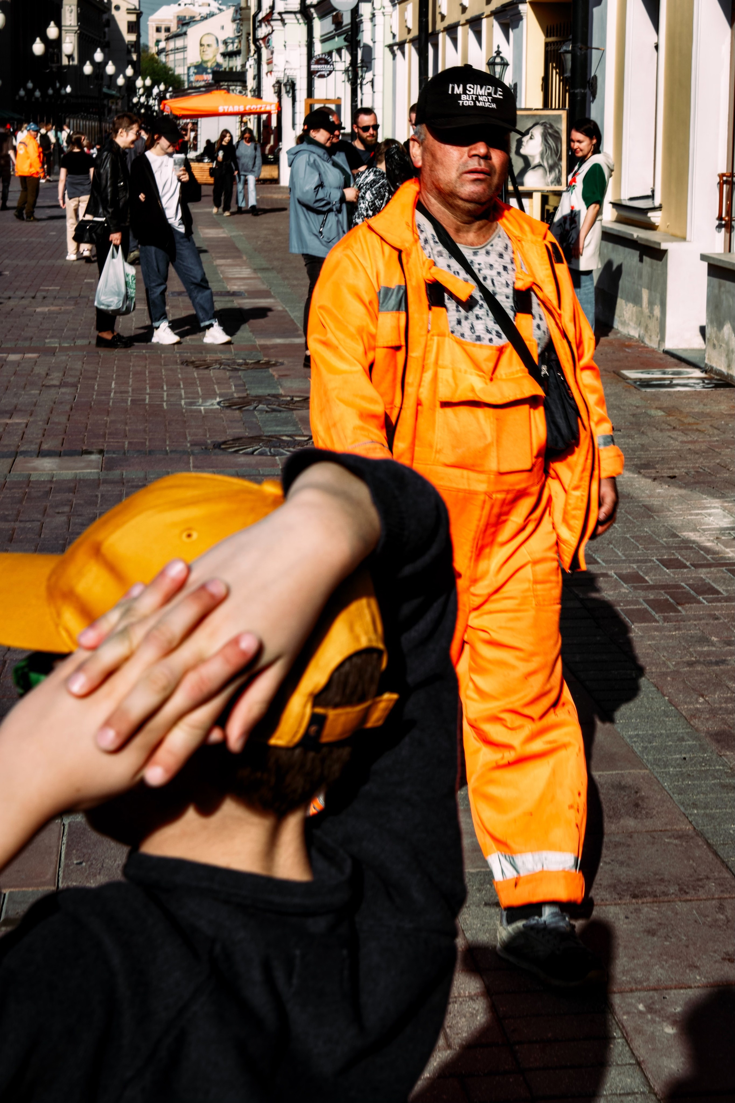 Мальчик в оранжевой кепке и рабочий в оранжевой форме на Старом Арбате