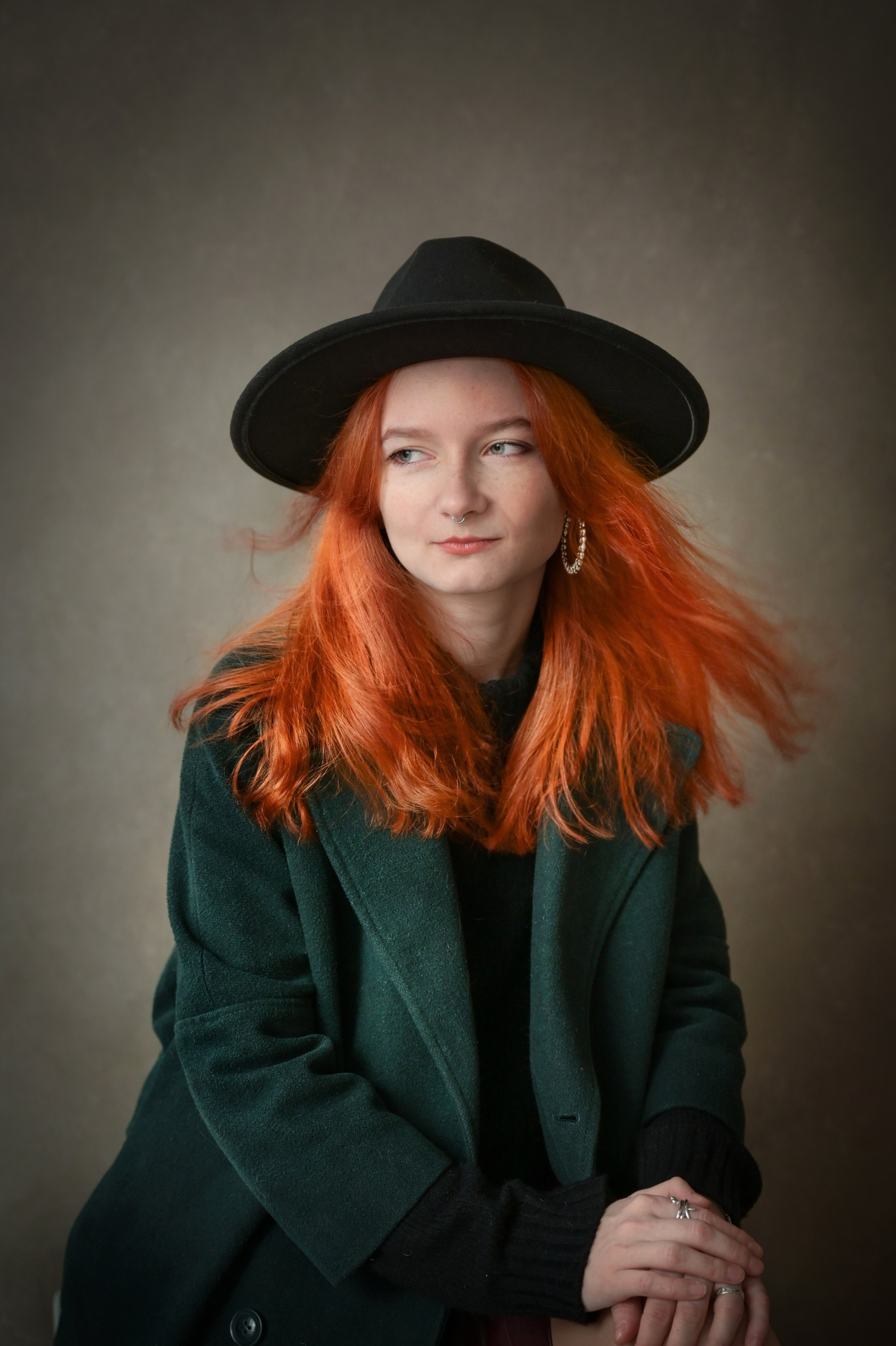Студийный портрет девушки в зеленом пальто и шляпе с огненно-рыжими волосами