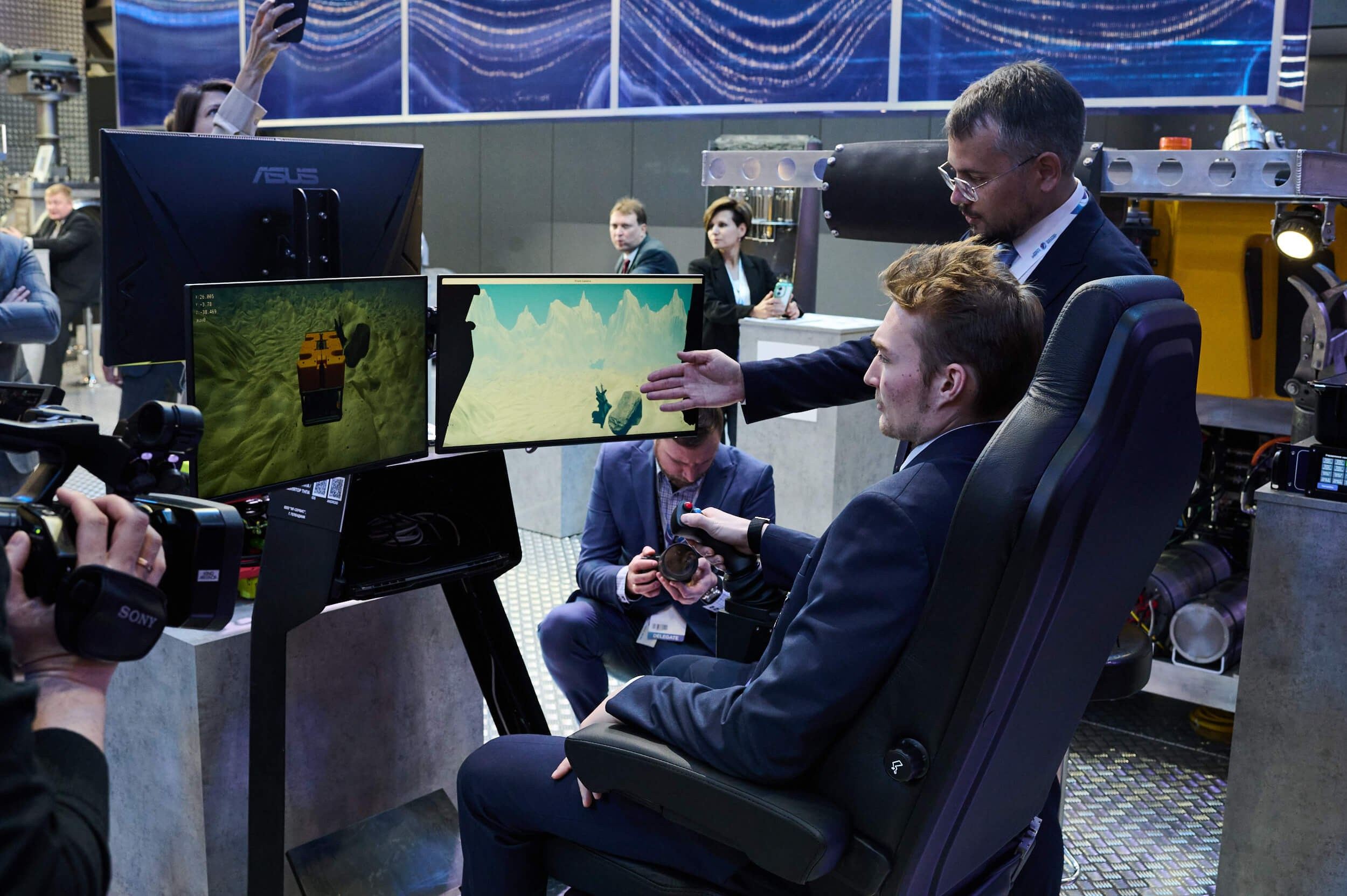 Вратарю команды СКА демонстрируют экспонат на выставочном стенде Петербургского международного газового форума 2025 в Экспофоруме