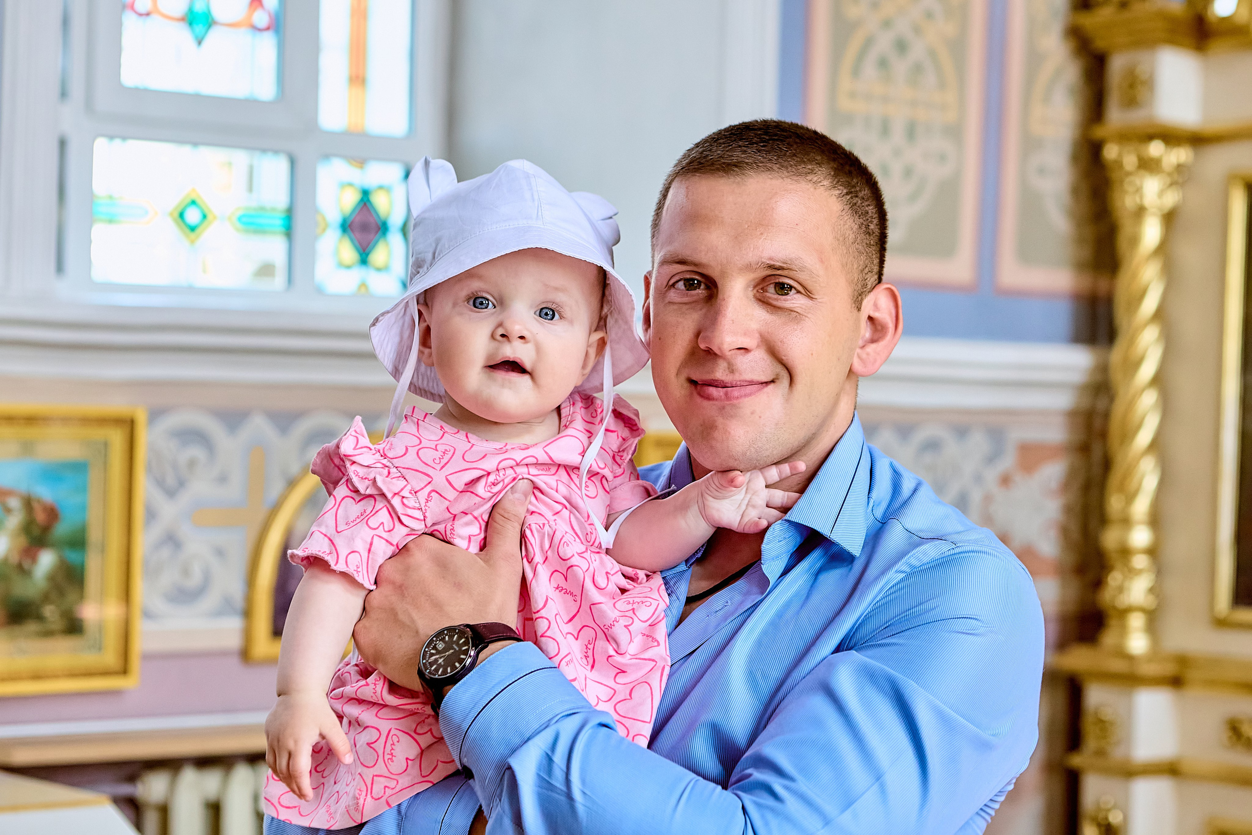 Малышка на руках у папы перед таинством крещения Молодой человек папа держит на руках свою дочку радуются на лицах улыбки