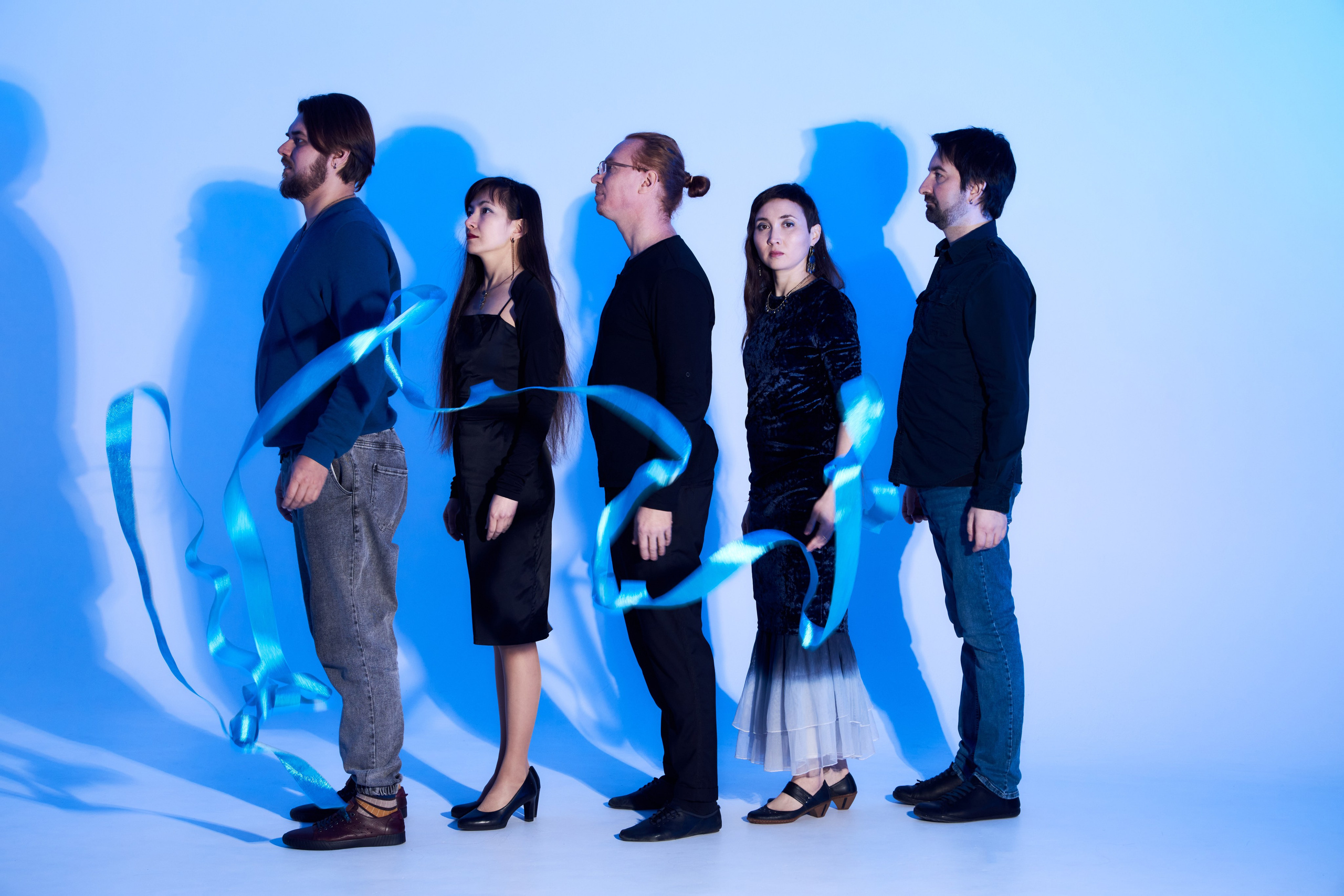 Групповое фото пяти человек с лентами и цветным светом