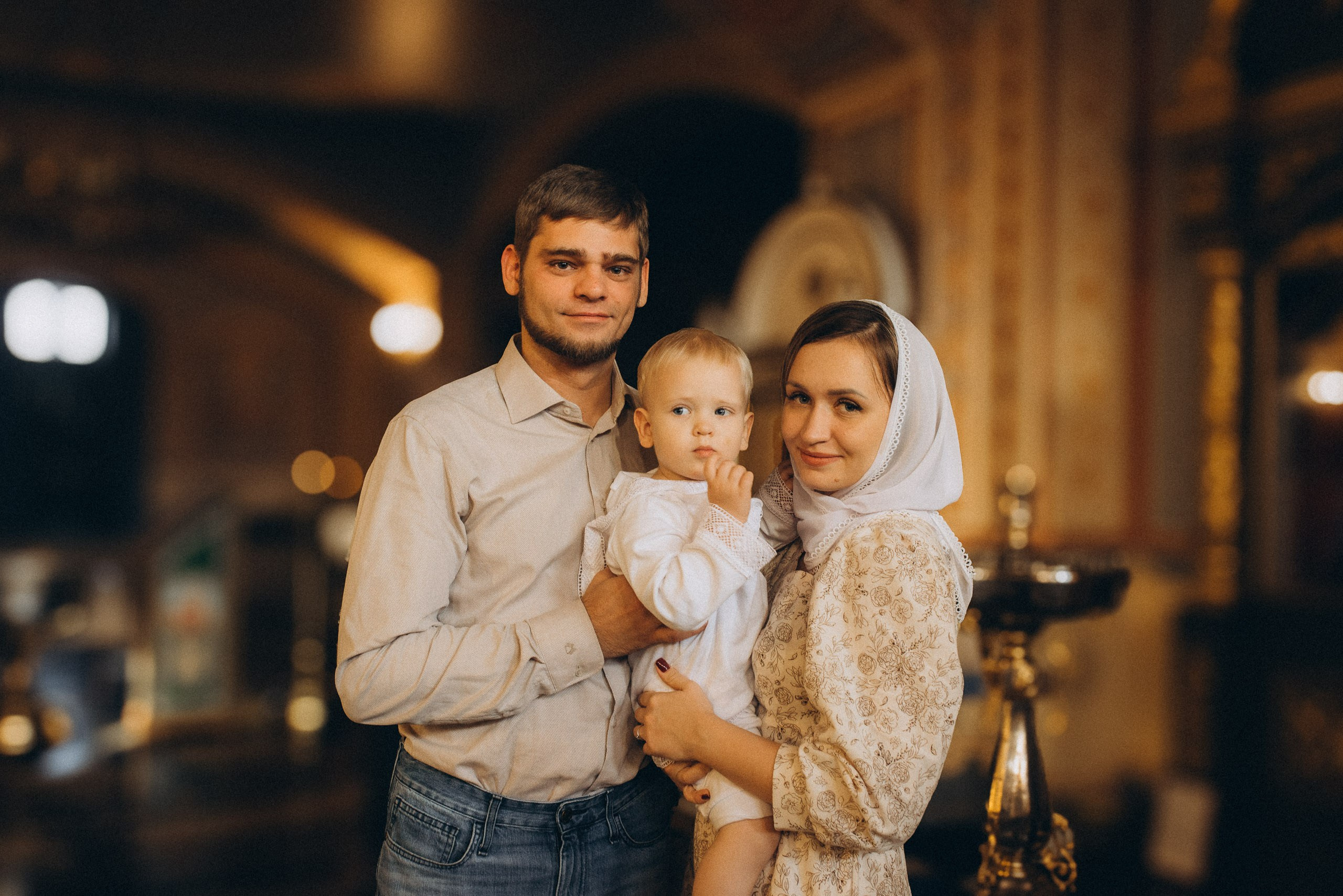Фотограф Василий Дан — Семейный портрет родителей с сыном во время Таинства Крещения в храме