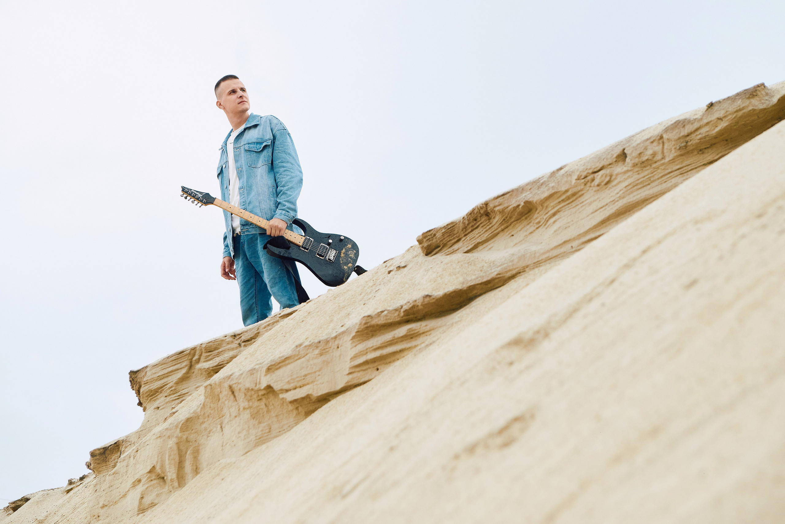 Парень играет на гитаре в пустыне