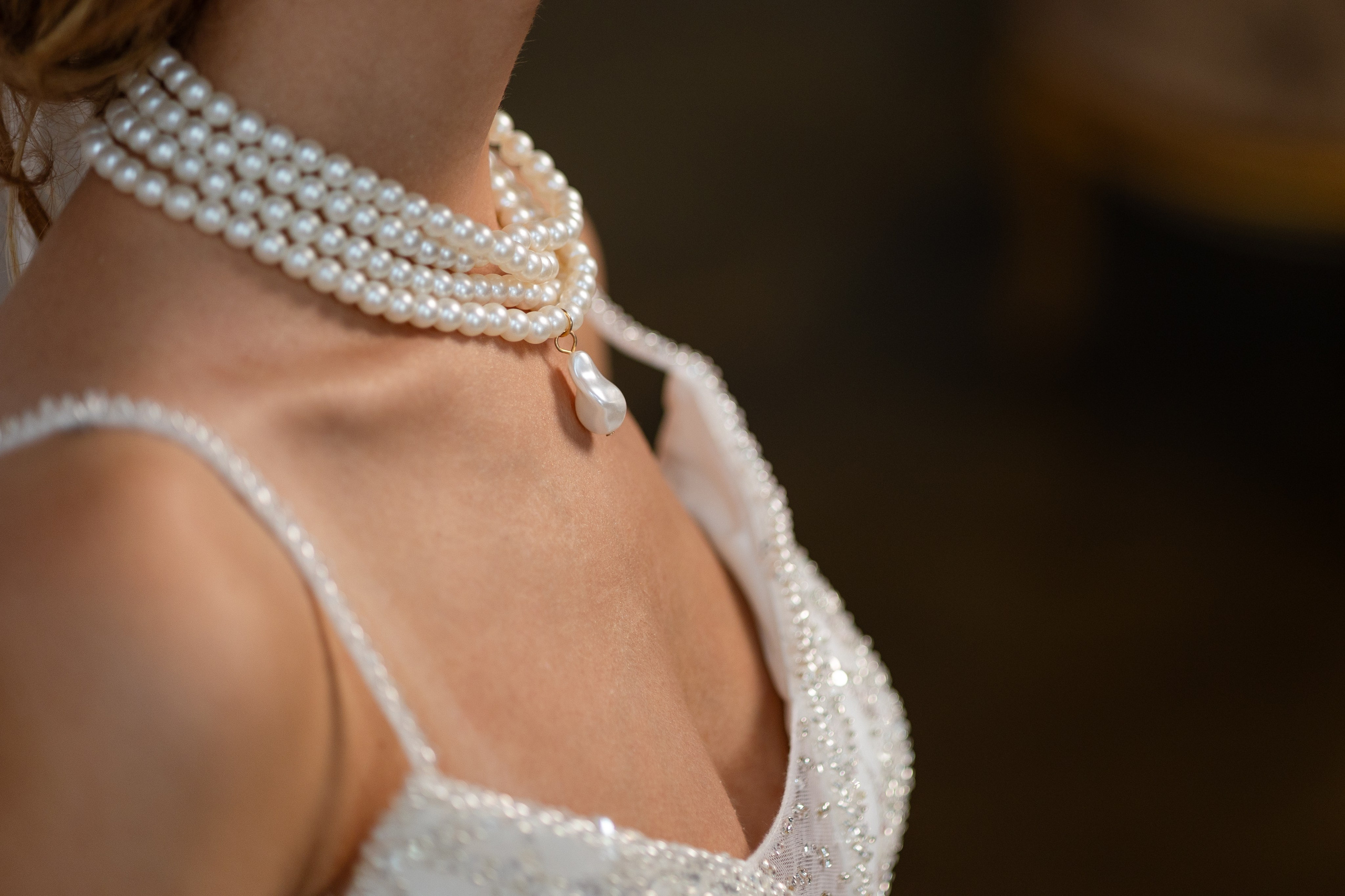 На фото крупным планом жемчужное ожерелье невесты