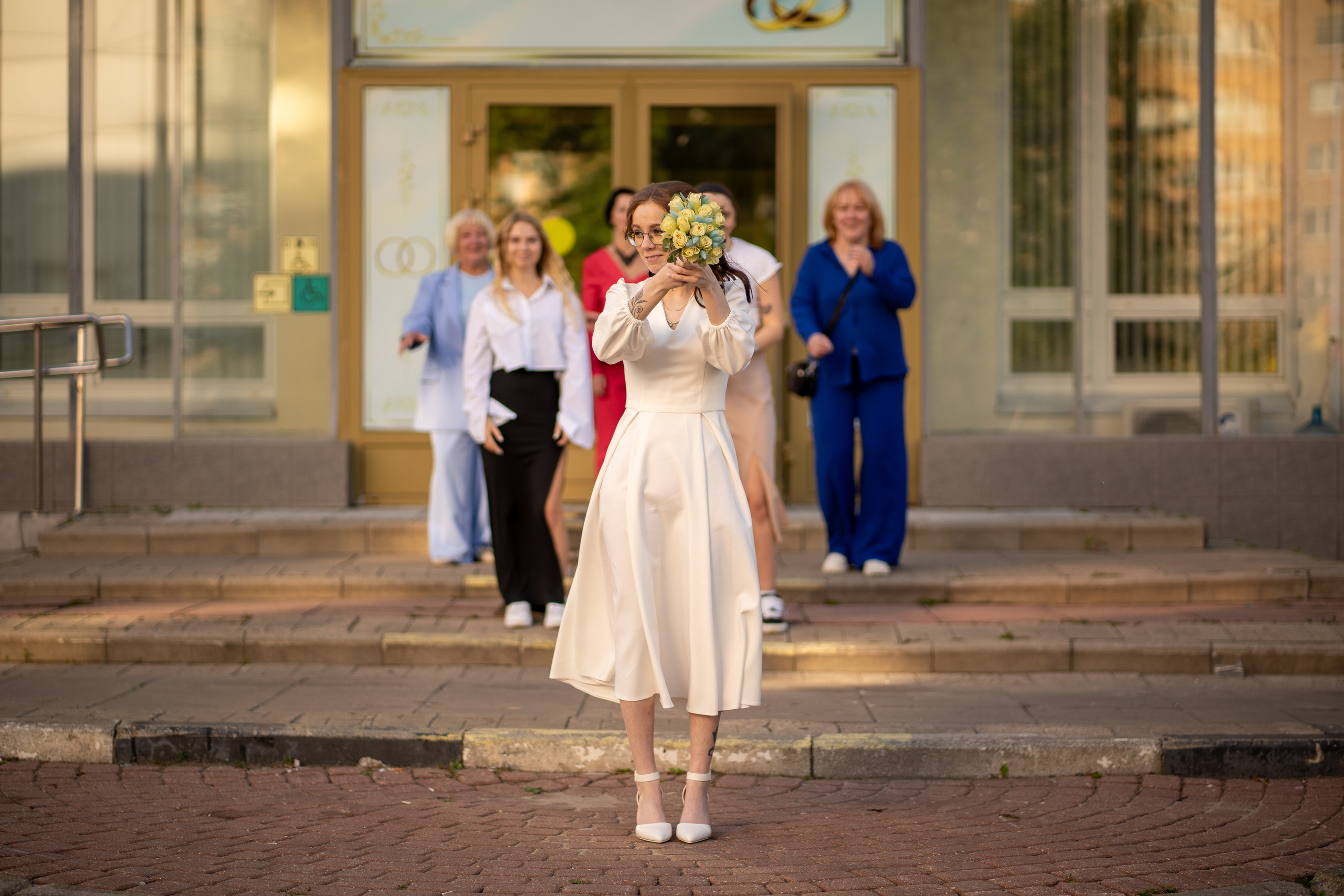 Невеста кидает букет невесты у загса