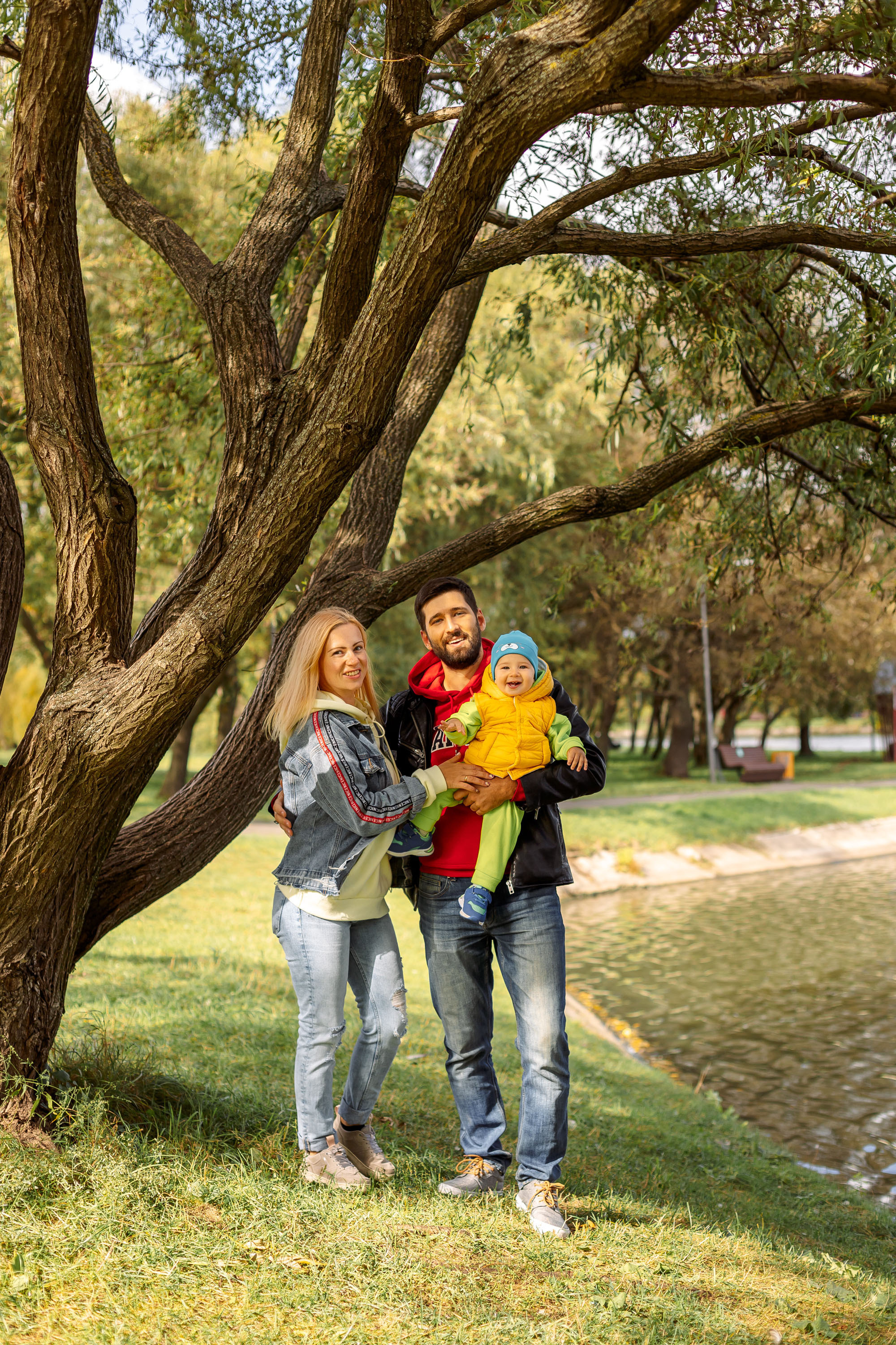 семья стоит у красивого дерева в парке