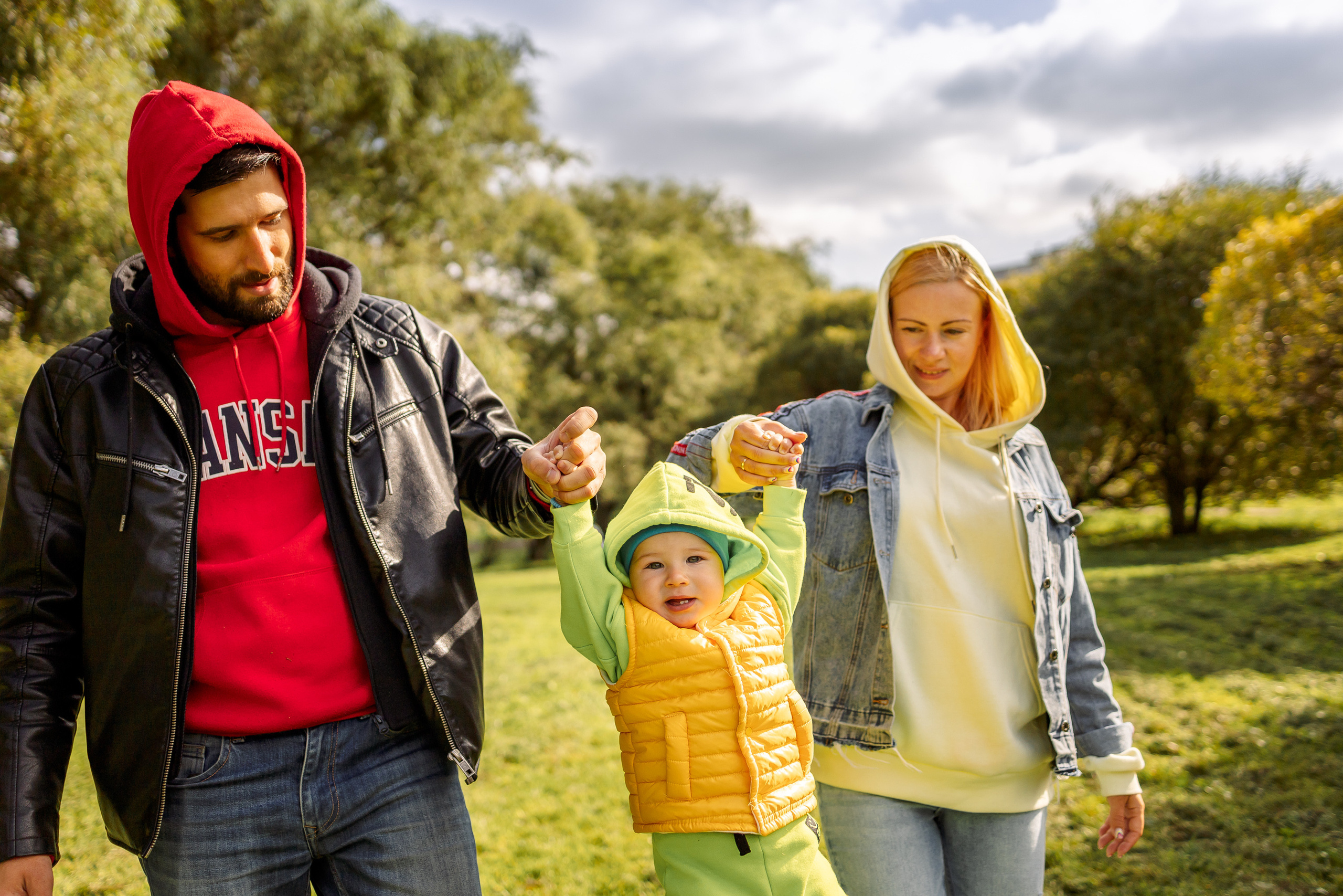 мама и папа поднимают малыша за руки