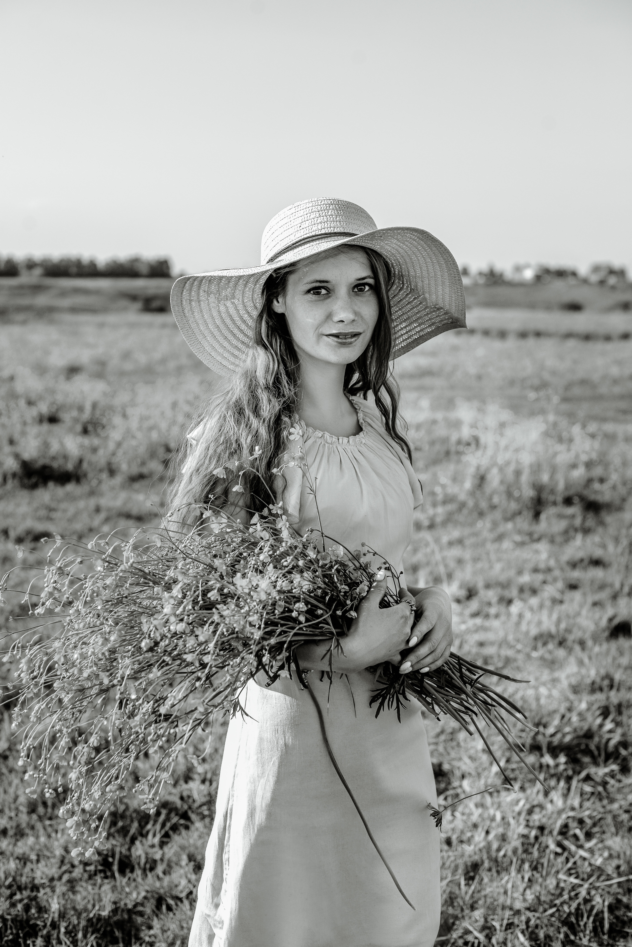 Девушка в шляпе с полевыми цветами в руках