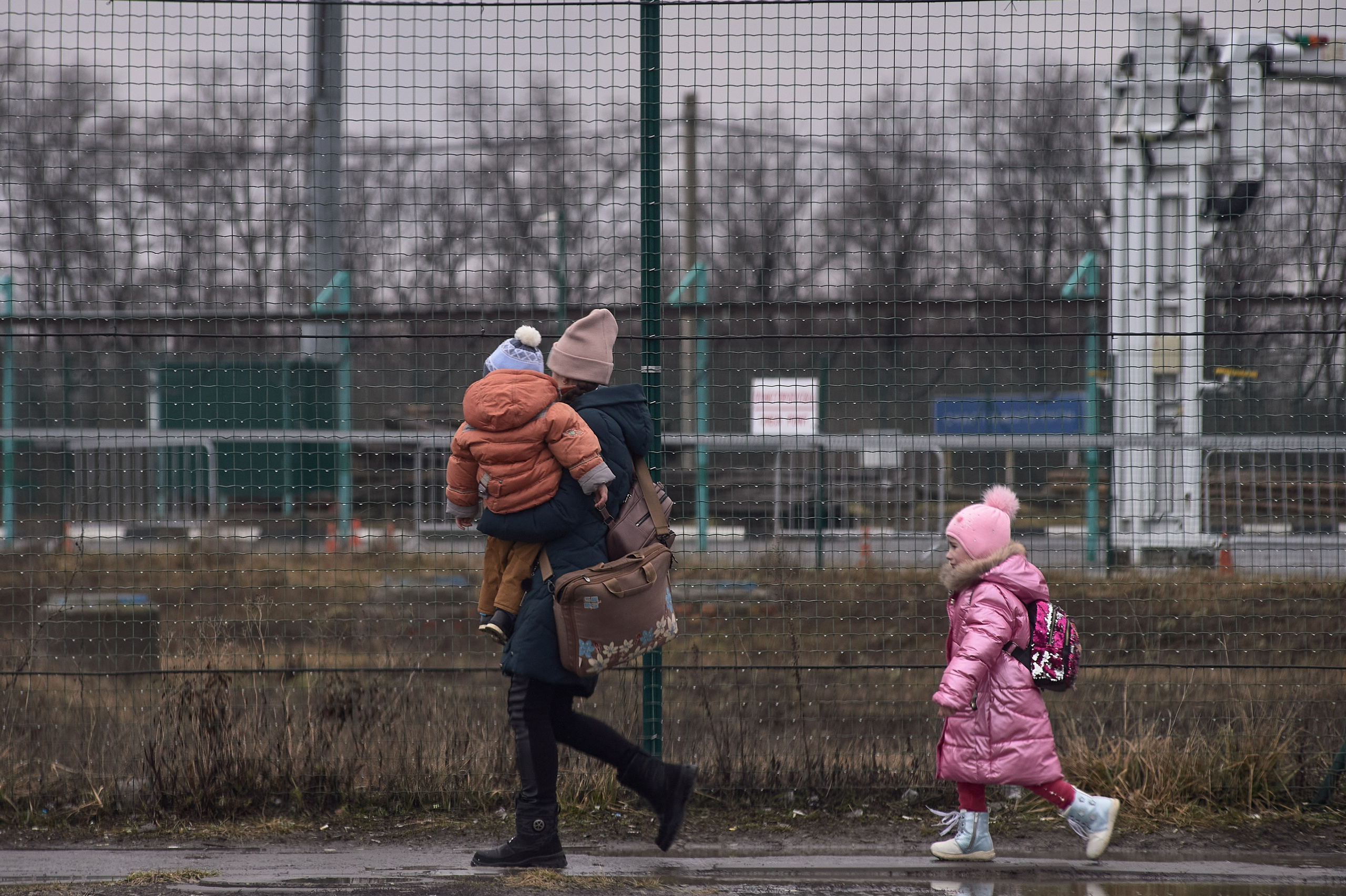 A woman with a child crosses a border checkpoint at the Russia-Donetsk border in Avilo-Uspenka village, Rostov region, on the day of Russia's full-scale invasion of Ukraine, February 24, 2022.