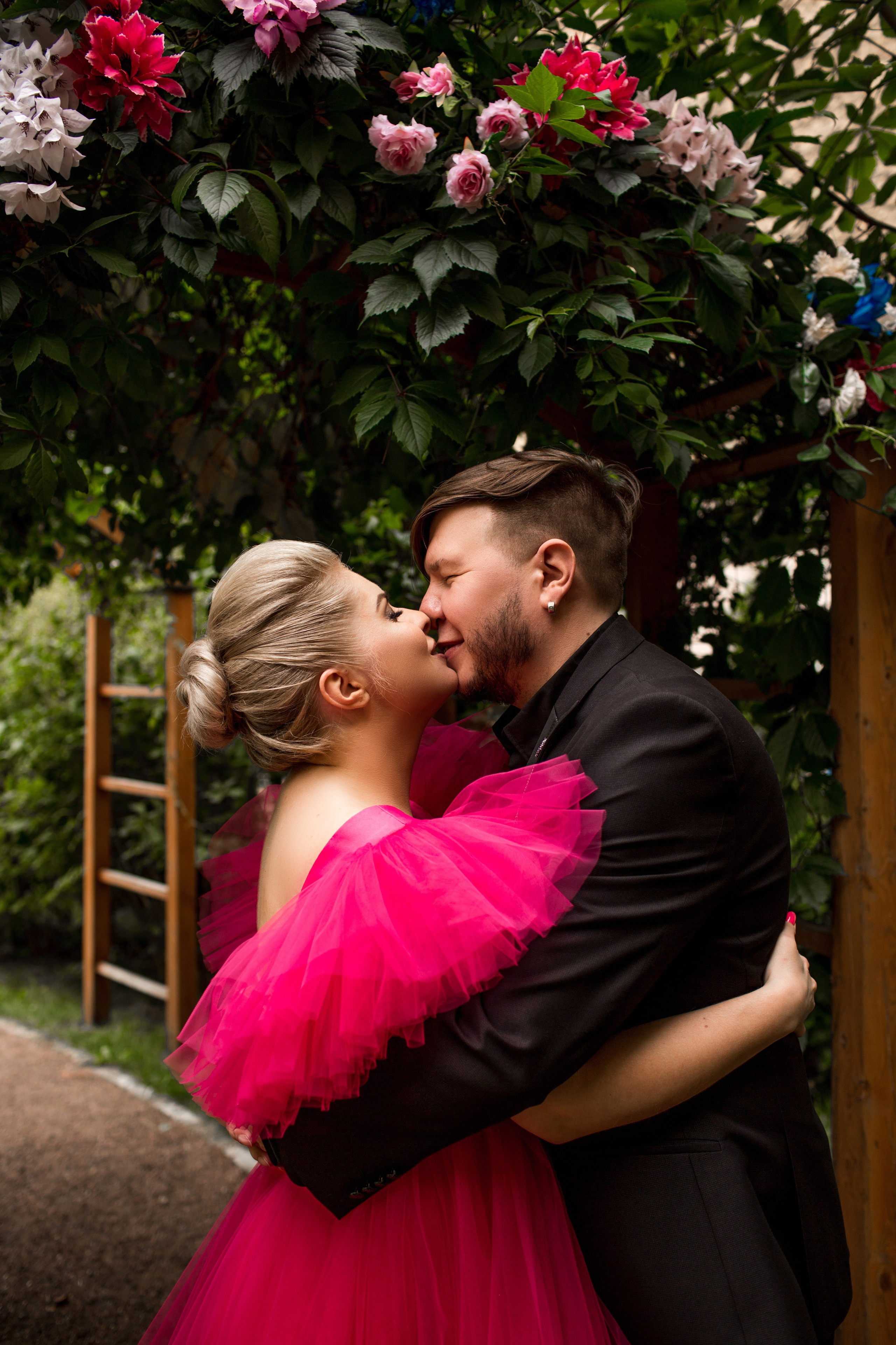 Невеста в красном свадебном платье обнимает жениха на улице Санкт-Петербурга