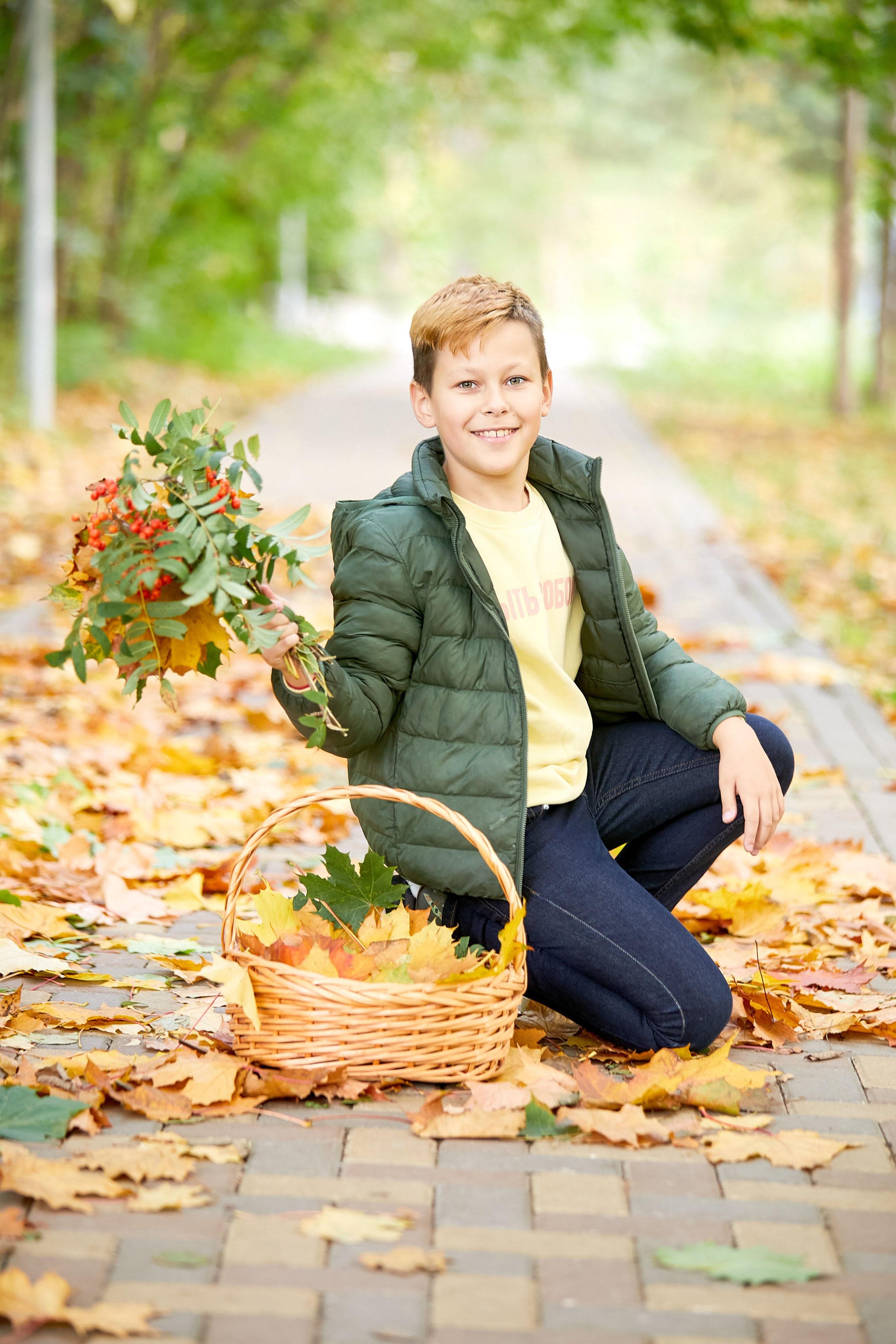 Мальчик сидит, позирует для фото с букетом