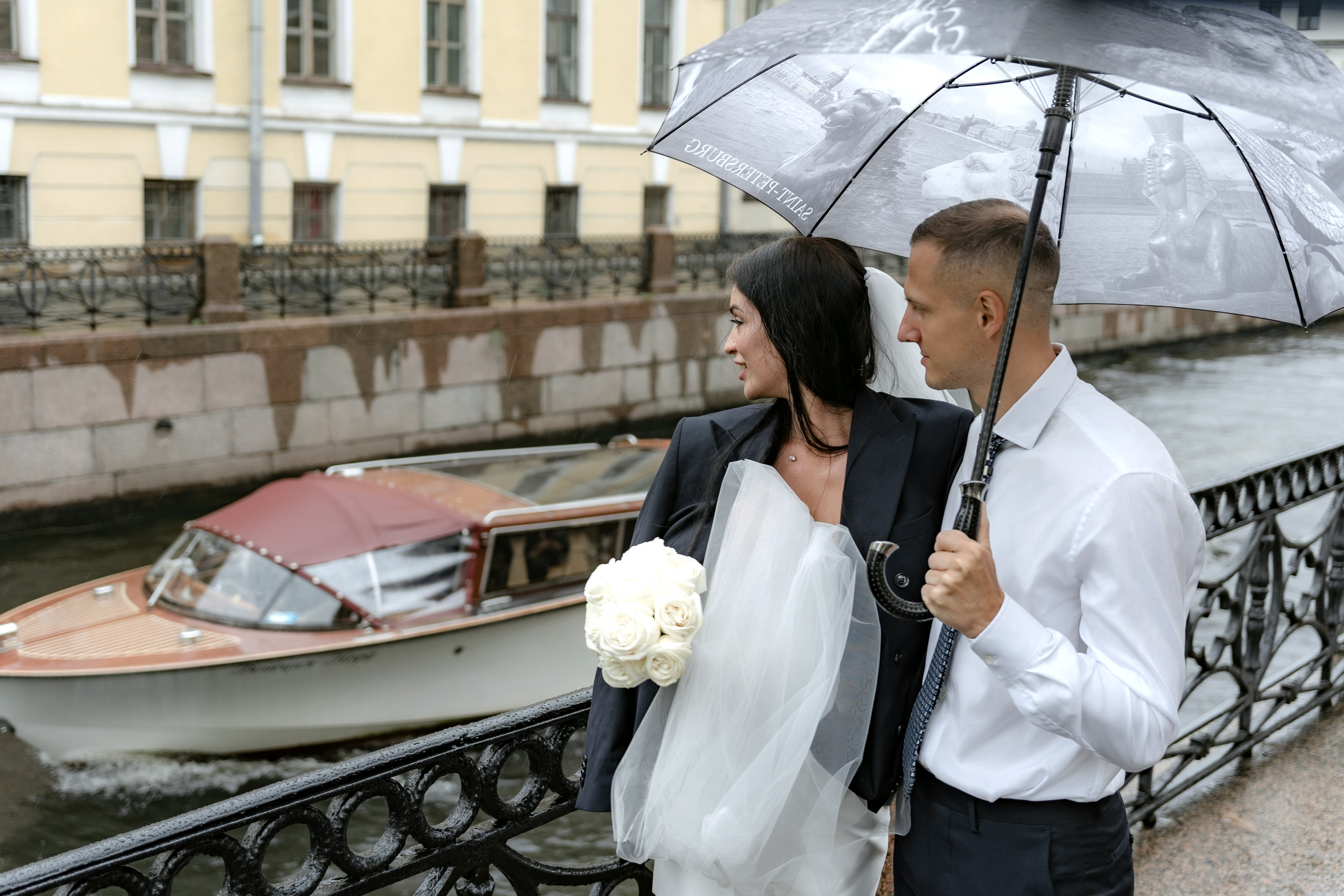 Жених и невеста на свадебной фотосессии на набережной под дождем  в Санкт-Петербурге