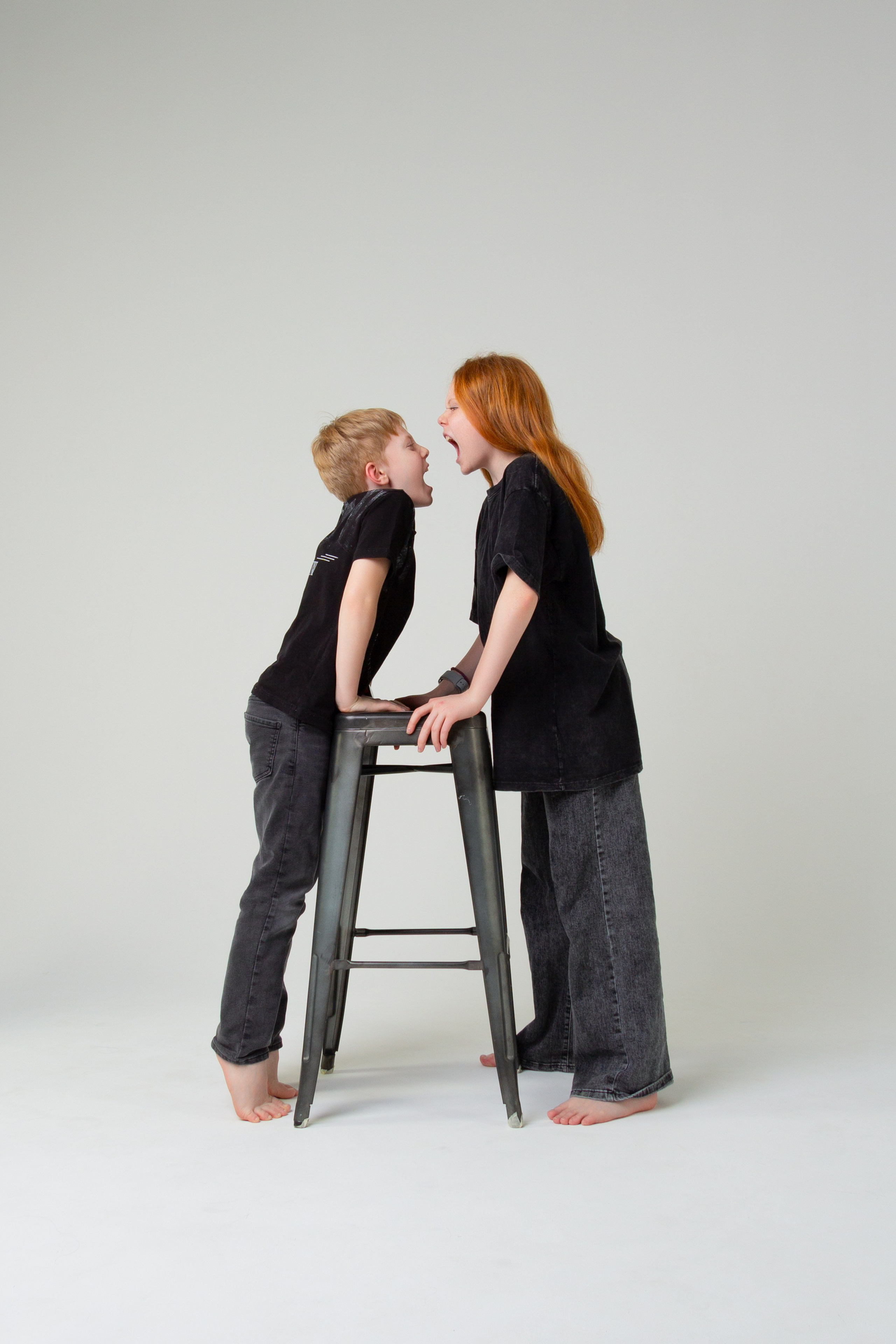 Фотосессия семьи, брат и сестра кривляются на камеру.