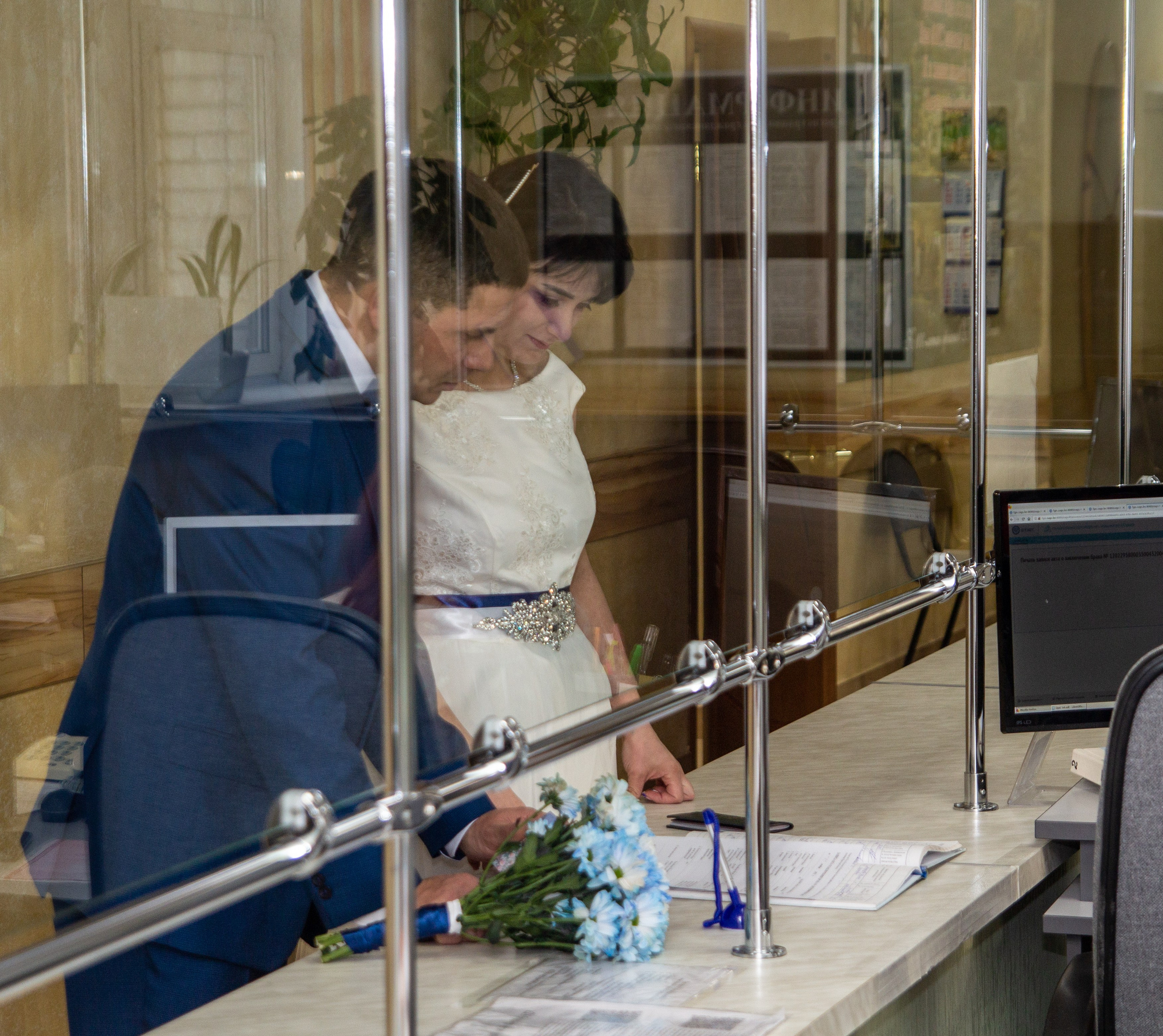 Жених и невеста подписывают документы в ЗАГСе — официальный момент регистрации брака.