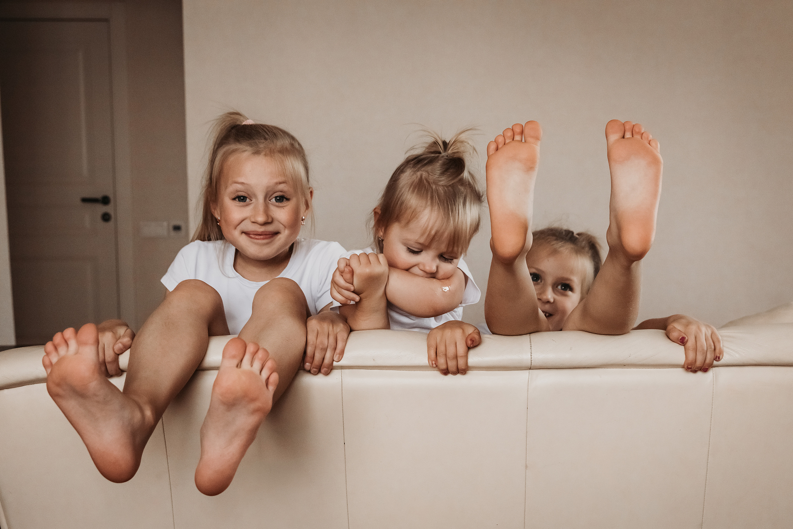 Три девочки сестрички балуются и показывают пятки