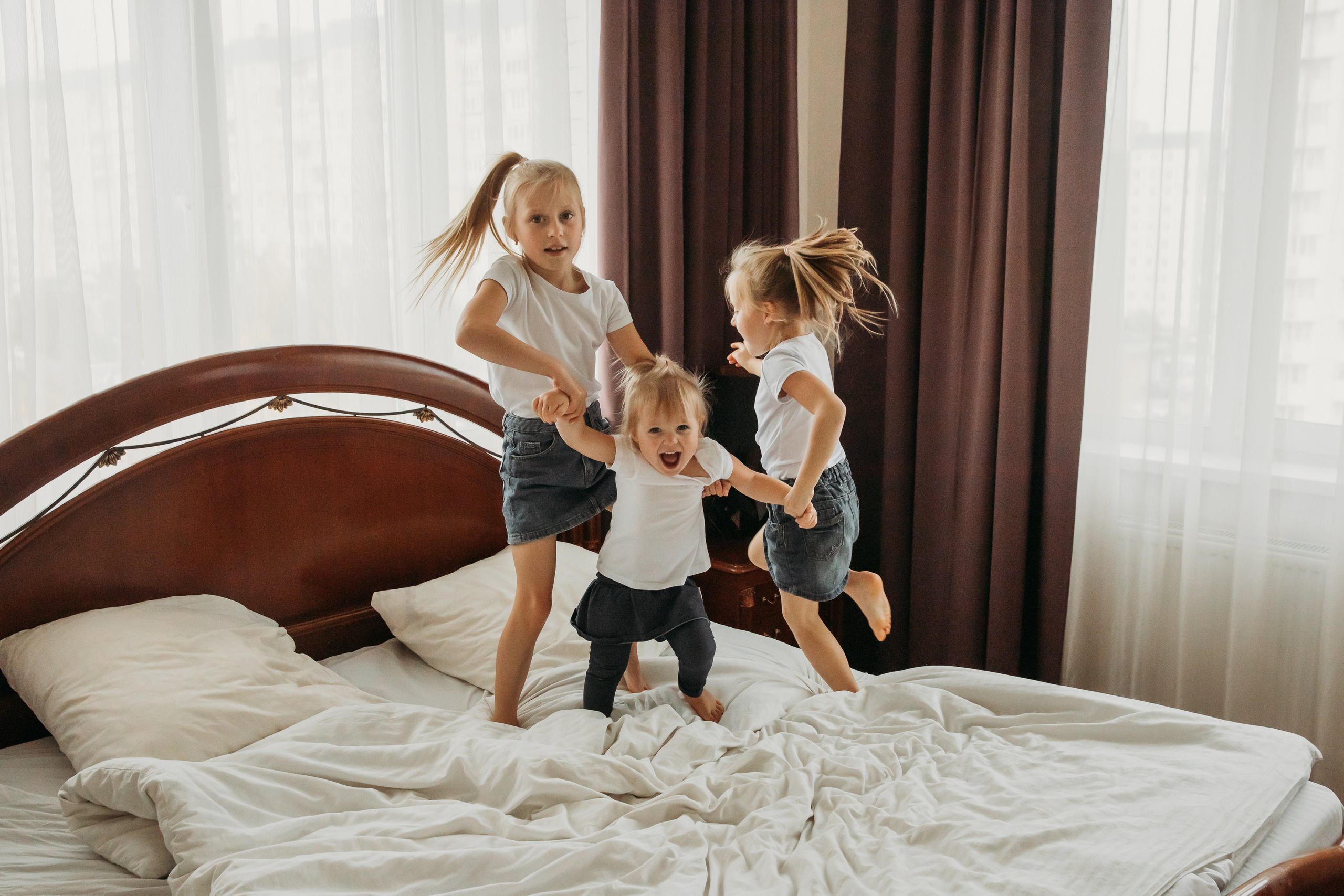 Три сестрички прыгают на диване 